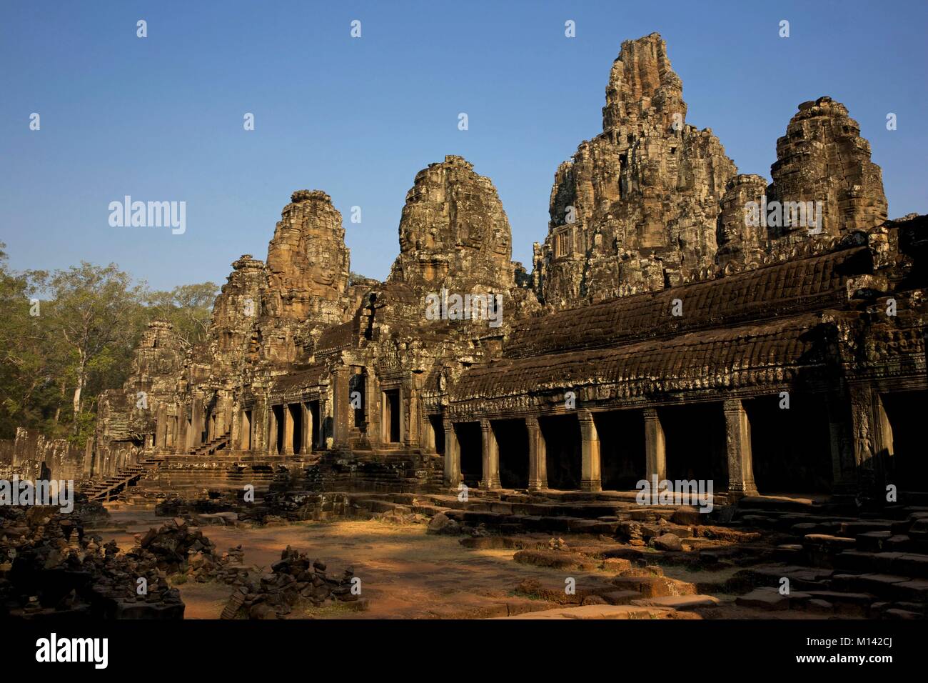 Cambodia, Angkor, listed as World Heritage by UNESCO, carved heads of Bodhisattva composing the Bayon, the main temple of the old khmer town of Angkor Thom, in the warm light of the early morning Stock Photo