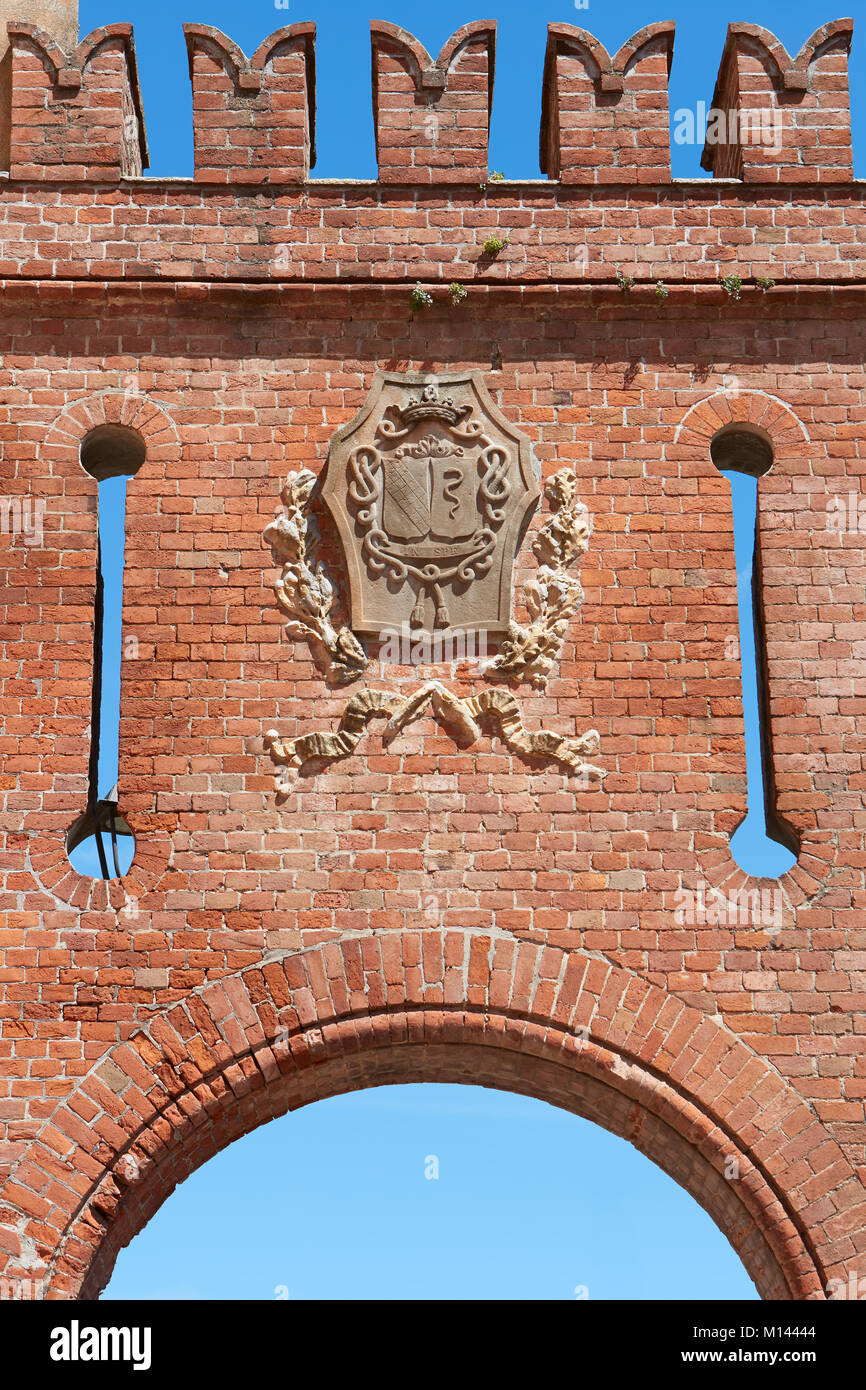 Barolo medieval castle entrance arch in red bricks with coat of arms in Barolo, Italy Stock Photo