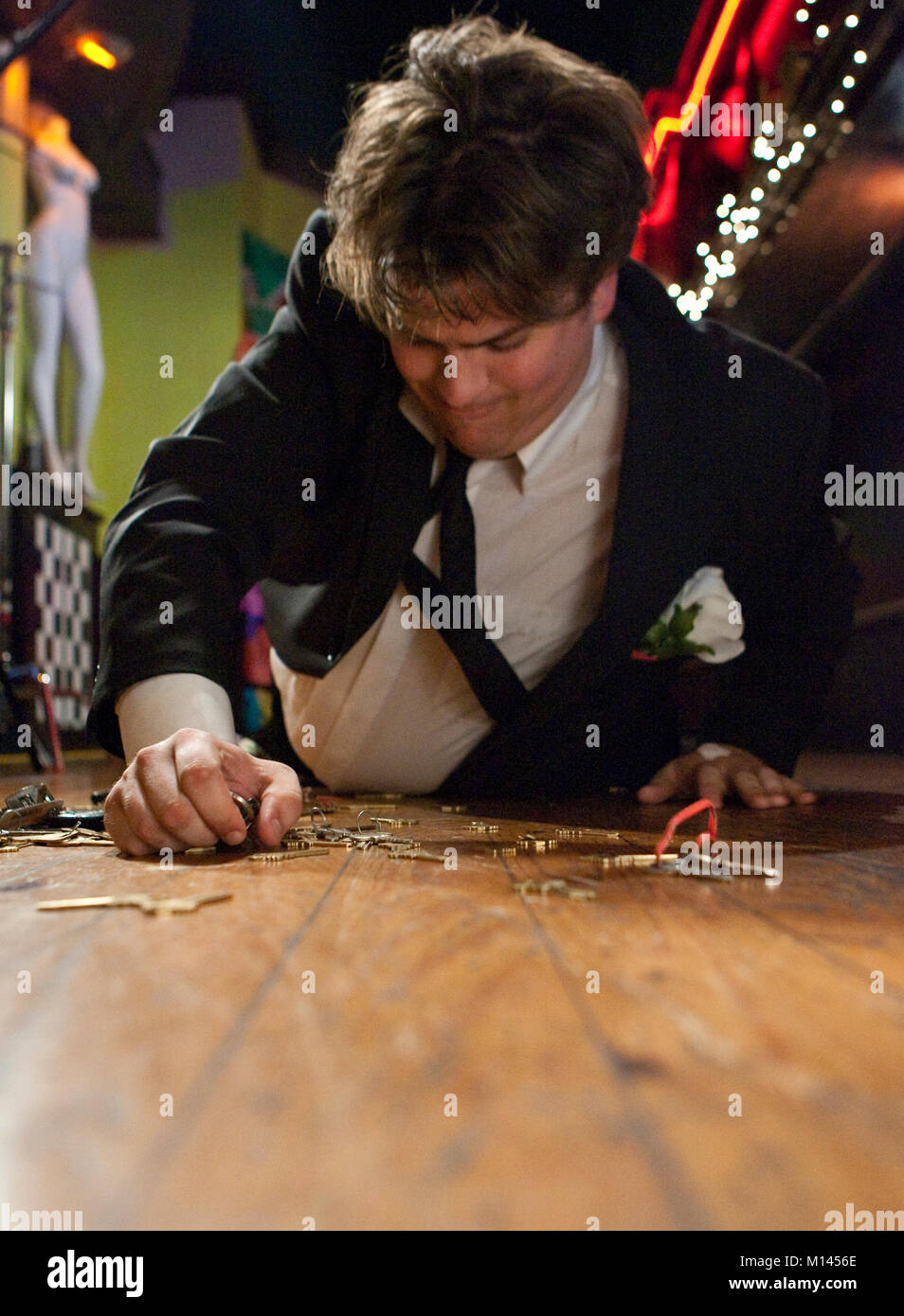 Drunk man on the bar floor, looking for his keys. Stock Photo