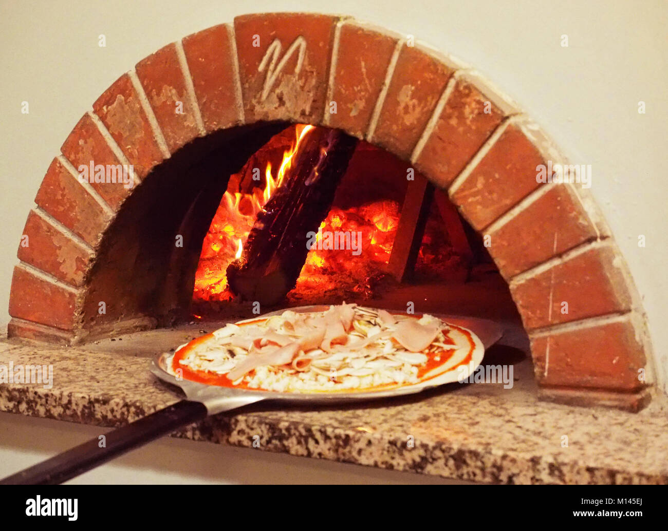 Europe,Italia,Pizzeria,Campania,Naples,Chef pulling pizza from oven Stock Photo