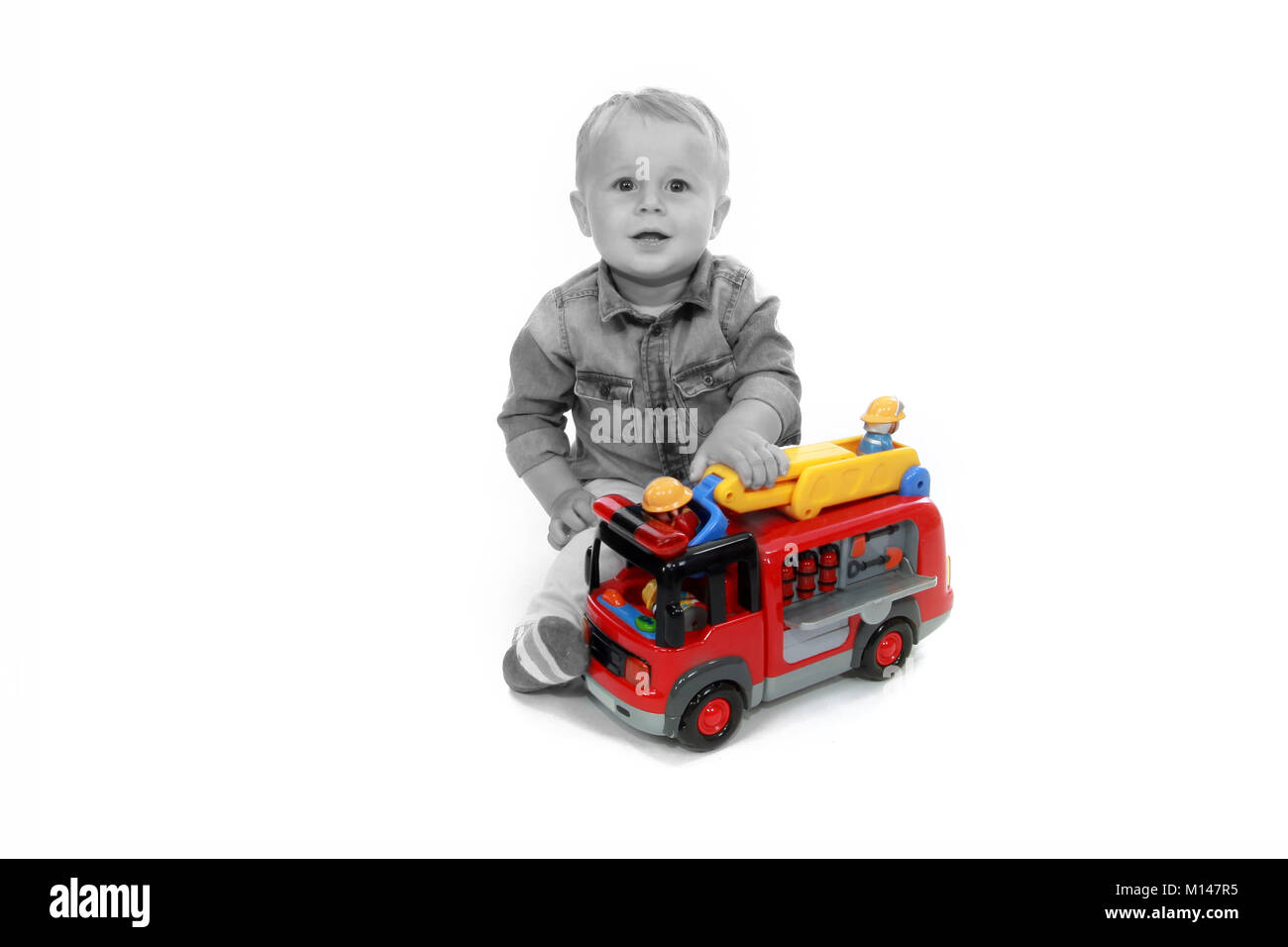 19 month old toddler playing with toy fire engine, childhood development Stock Photo