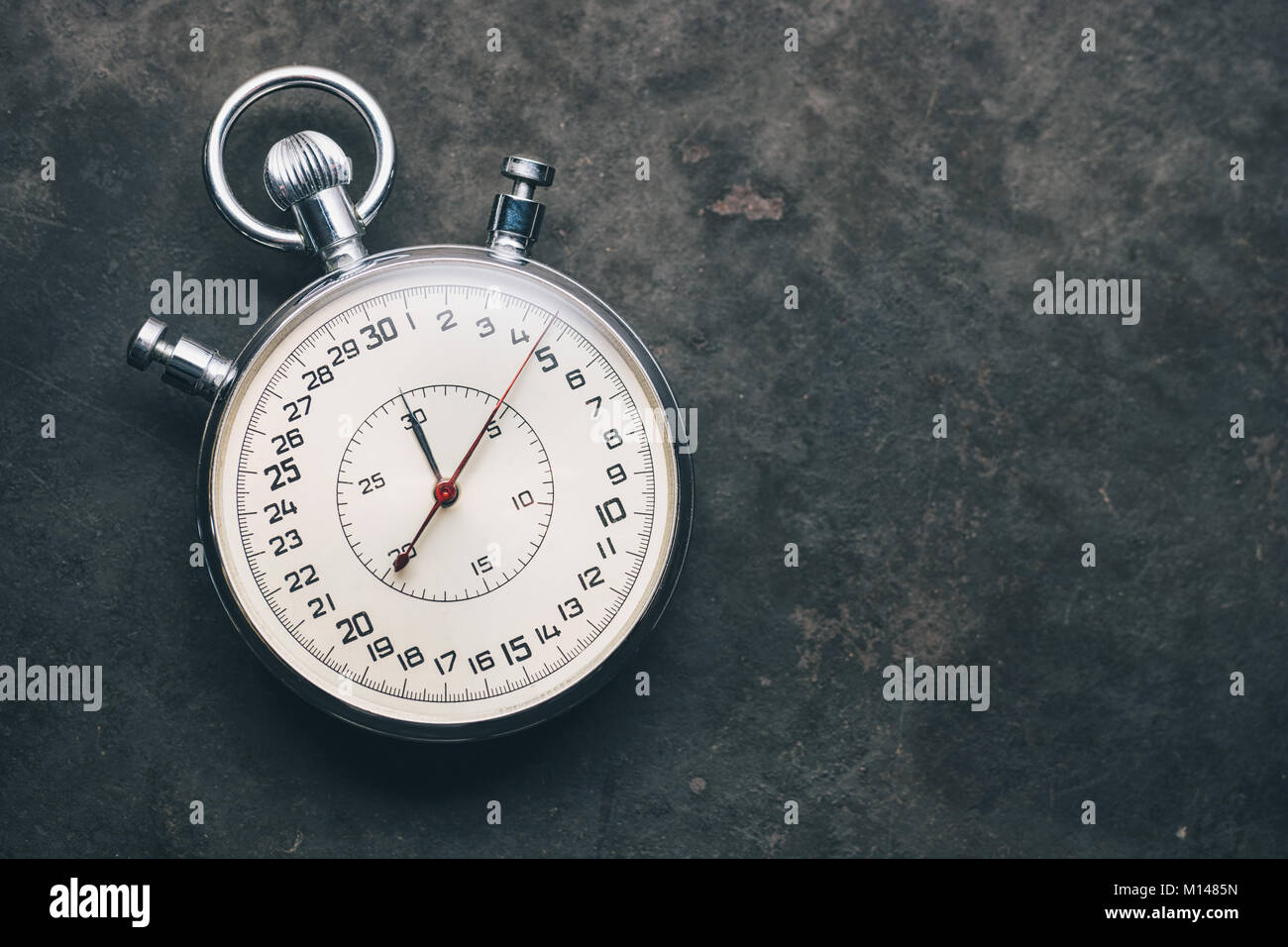 silver stopwatch on weathered background, including copy space. Stock Photo