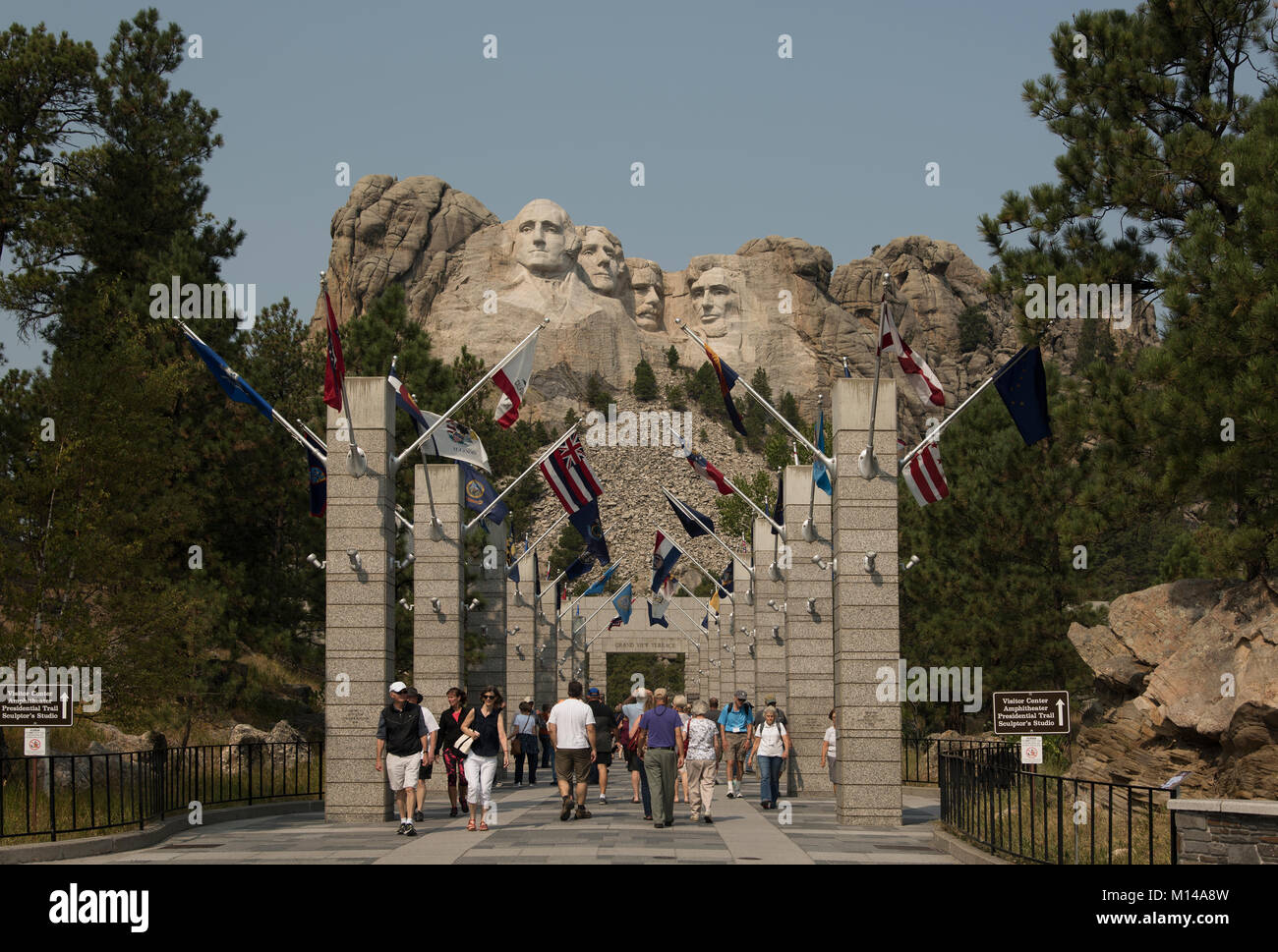 Tourists walk to the grand view terrace to view Mt. Rushmore Natl. Monument, South Dakota, USA.  The carvings,out of granite stone, are 60 feet in hig Stock Photo