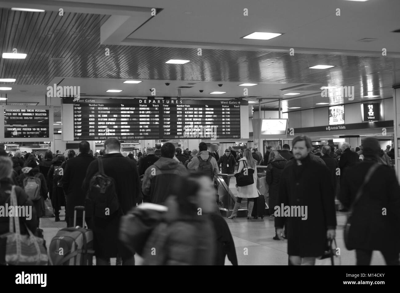A tired crowd is waiting in front of departure table at NYC Penn Station for train home Stock Photo