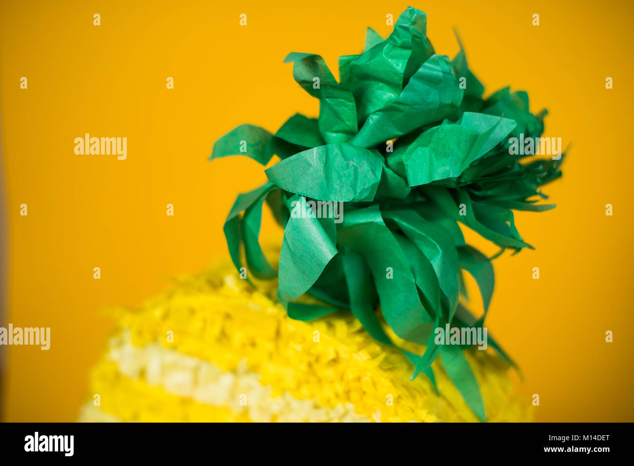 A pineapple piñata among a yellow backdrop Stock Photo