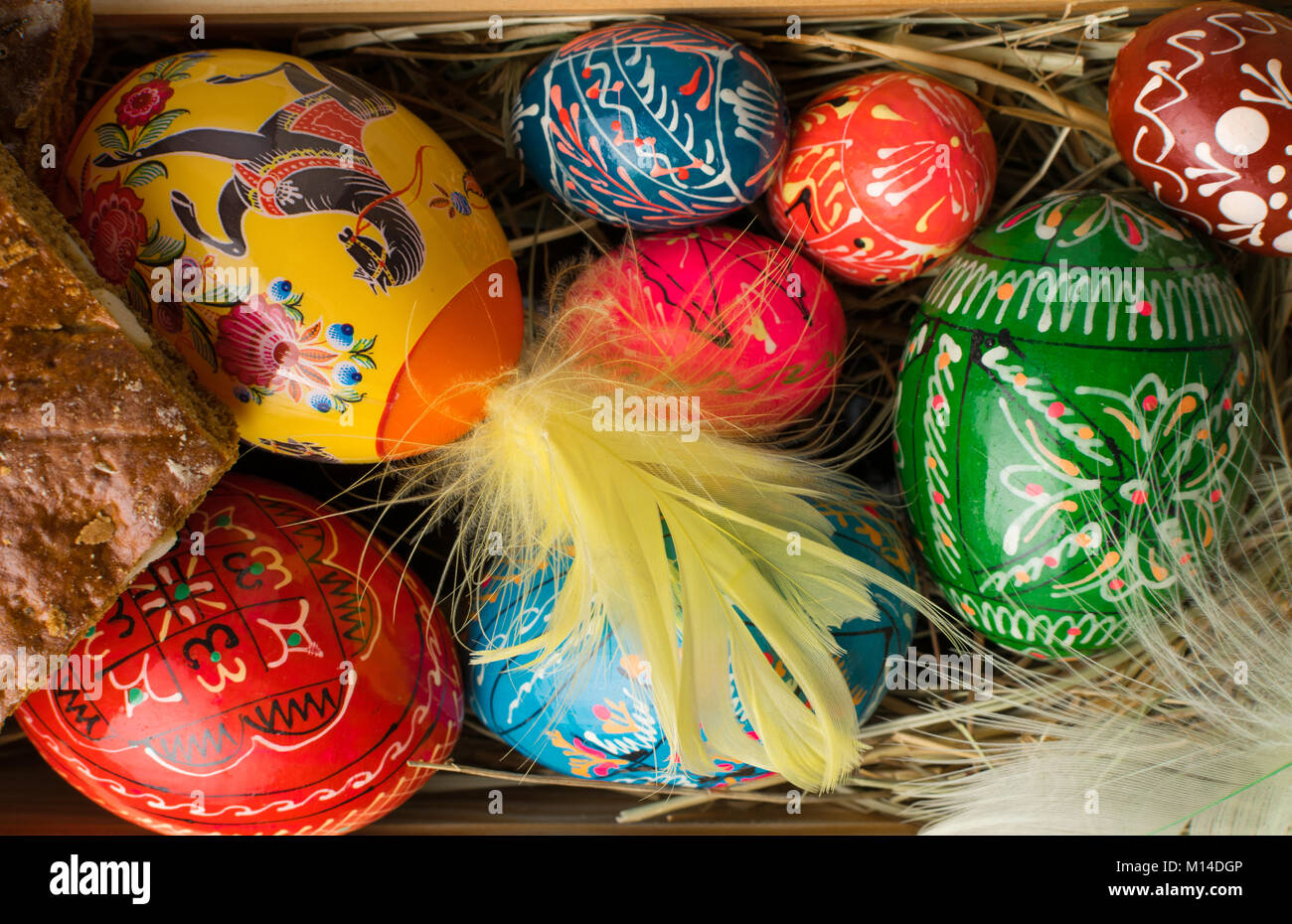 easter colored eggs and feathers on a wooden background Stock Photo - Alamy