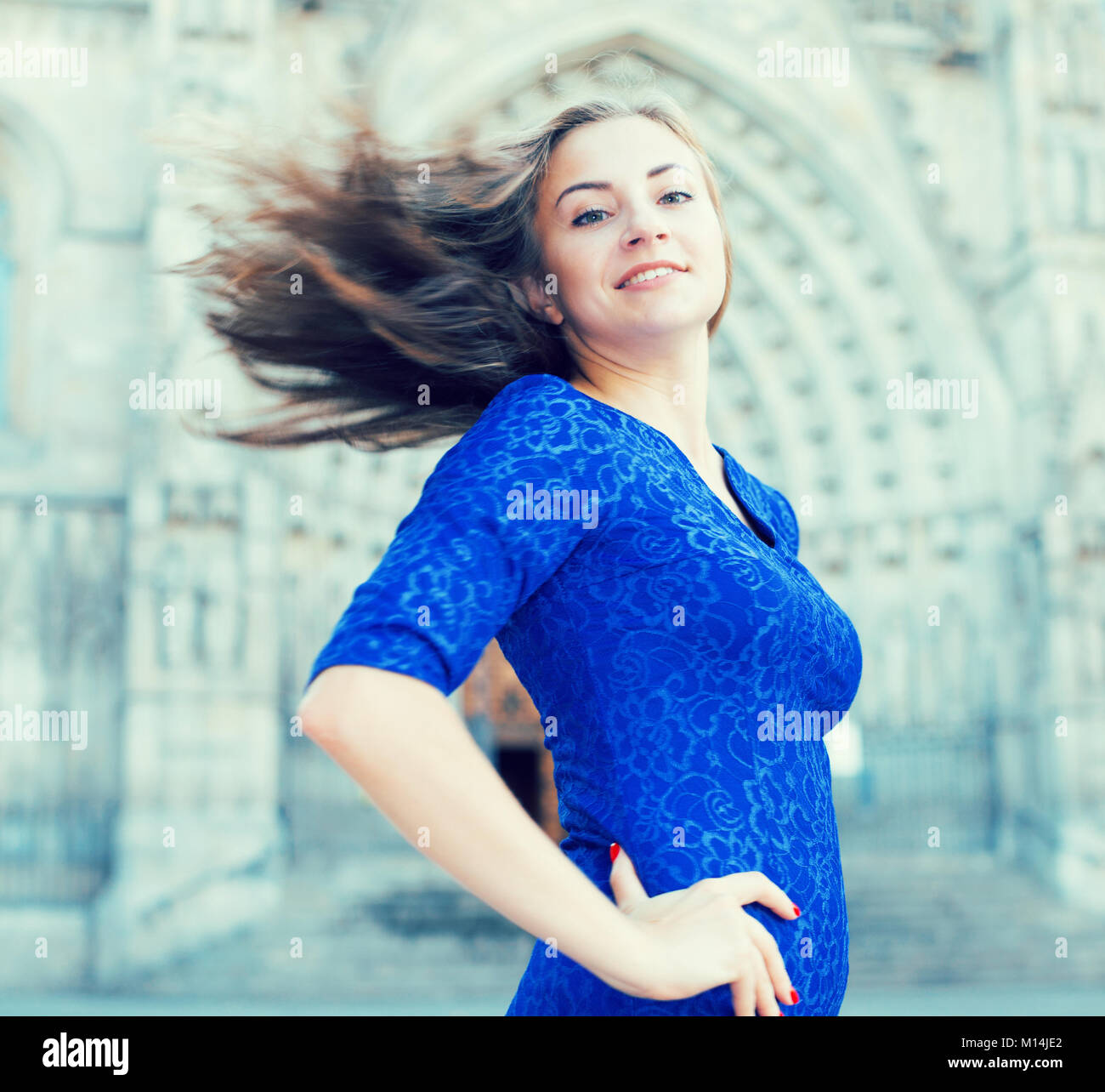 Elegant girl is posing in blue dress on the street of old city Stock ...