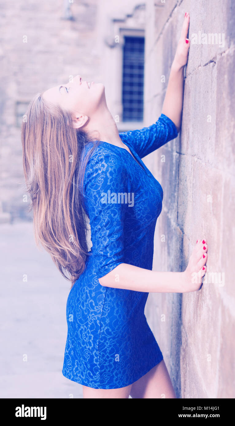 Elegant girl is posing in blue dress near old wall on the street Stock ...