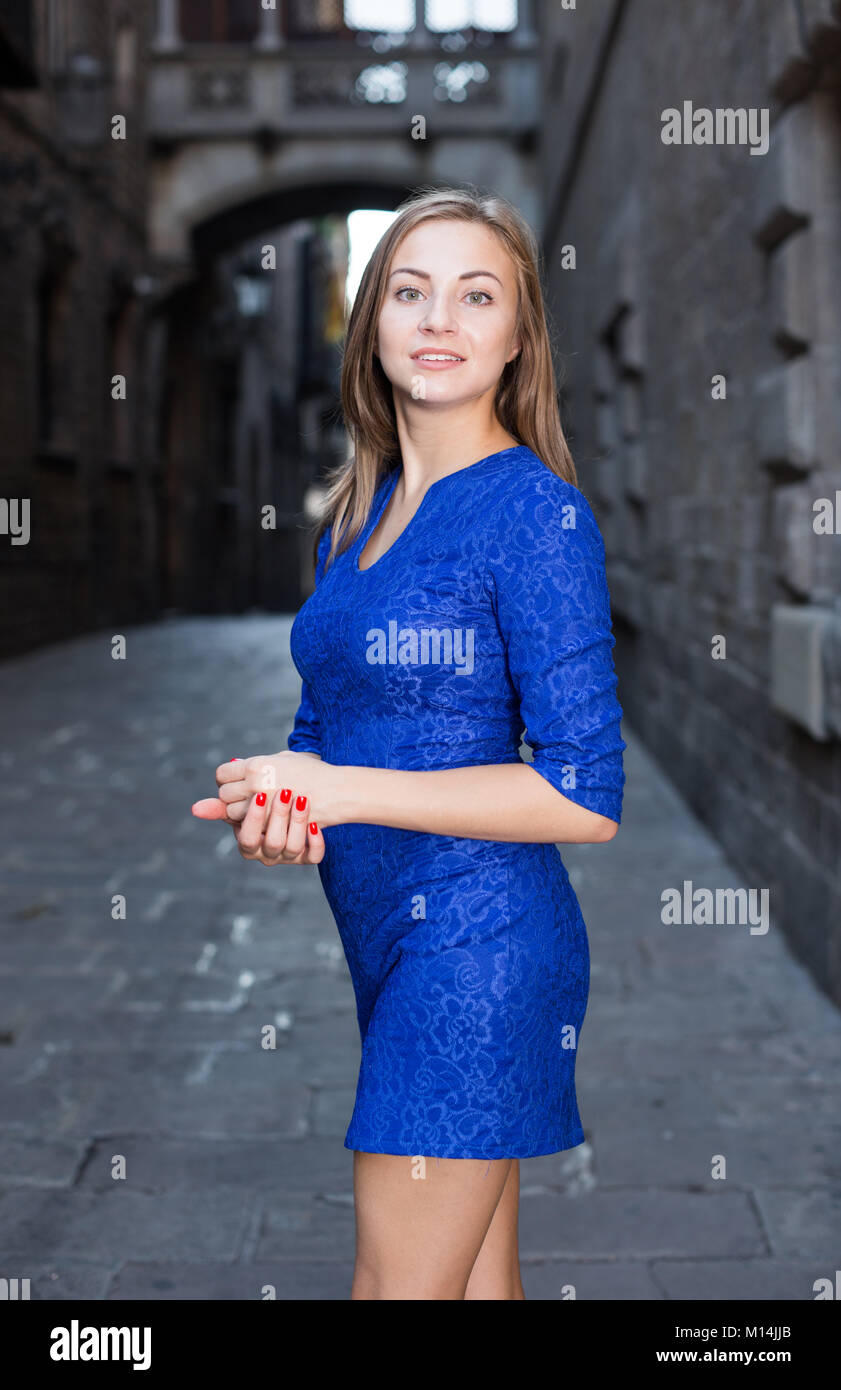 Young woman is posing in blue dress in old city Stock Photo - Alamy
