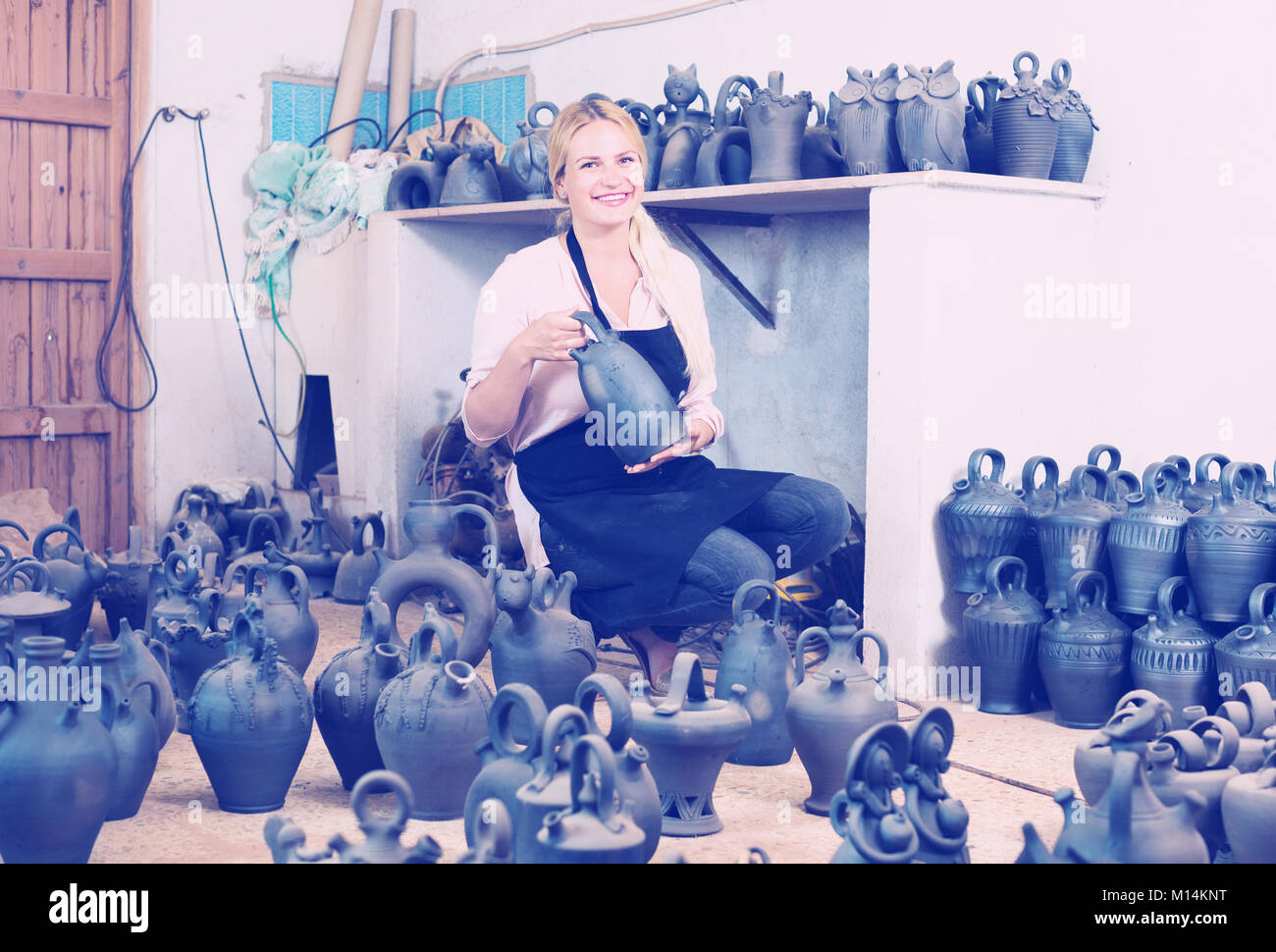 portrait of female artisan with black-glazed ceramic vases in atelier Stock Photo