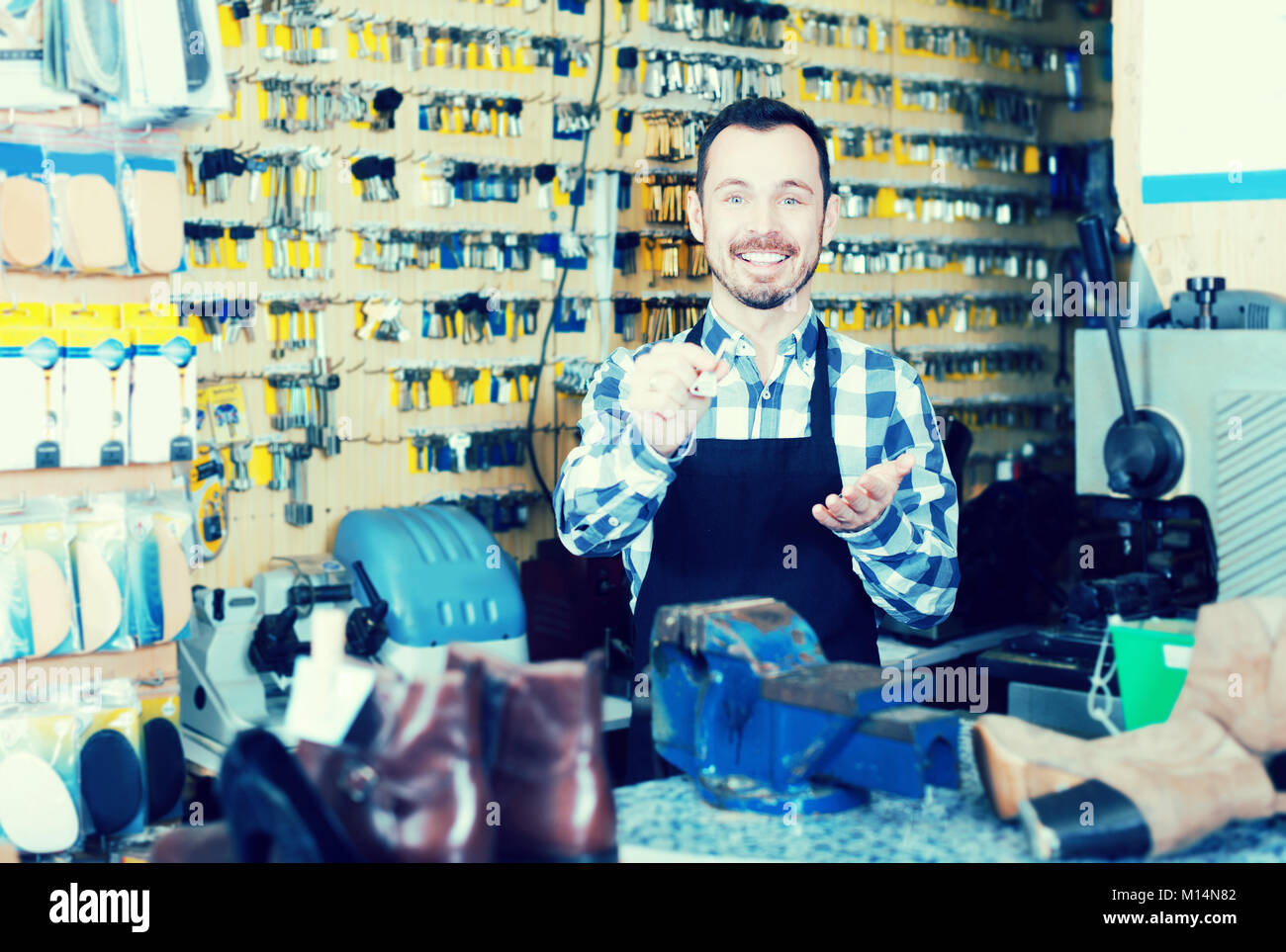 Keymaker Job Young man worker displaying result of his key making in workshop Stock ...