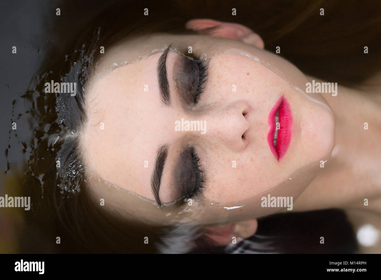 young beautiful woman lying in water with closed eyes Stock Photo - Alamy