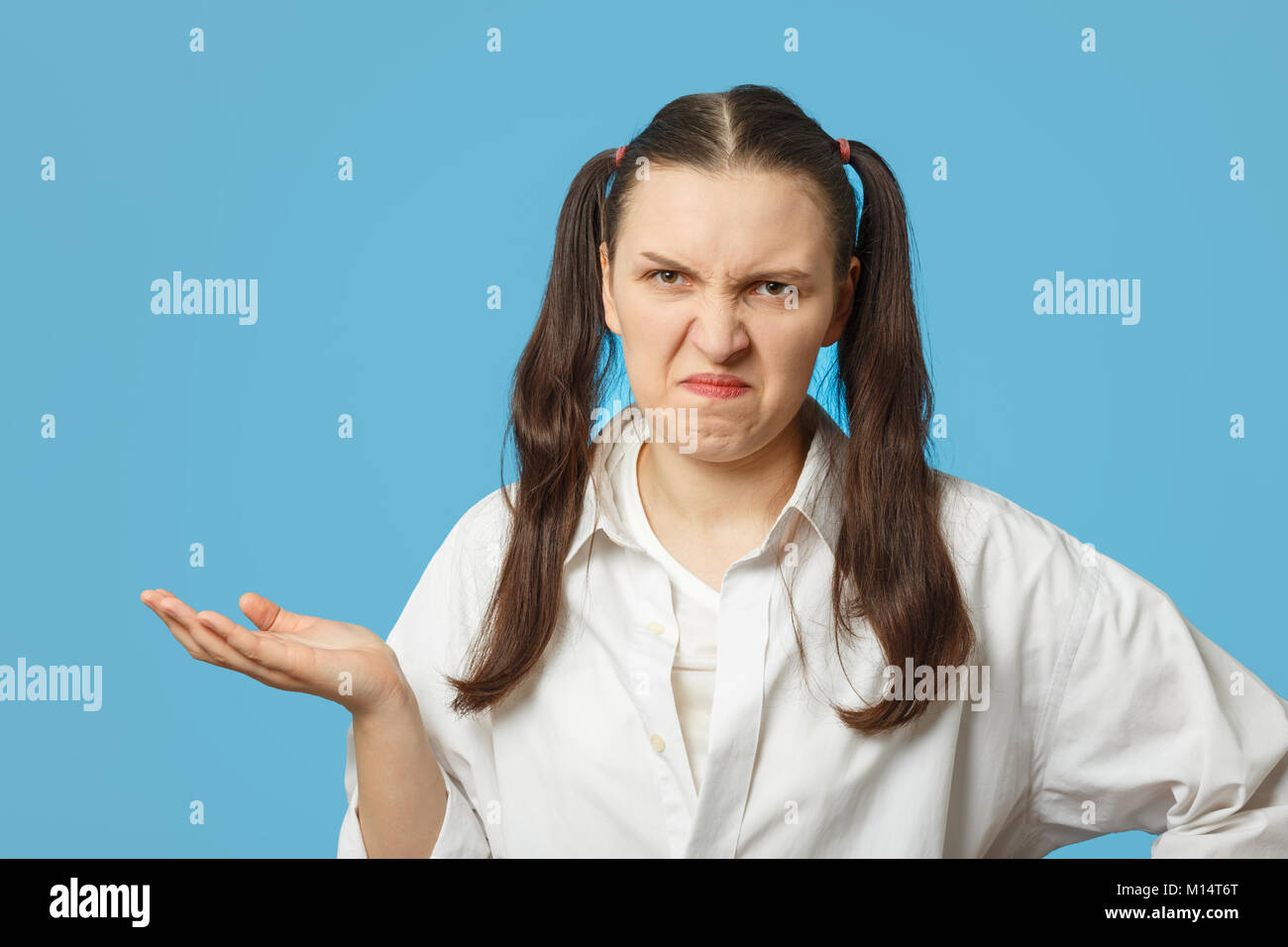 fun girl making a grimace on blue background Stock Photo