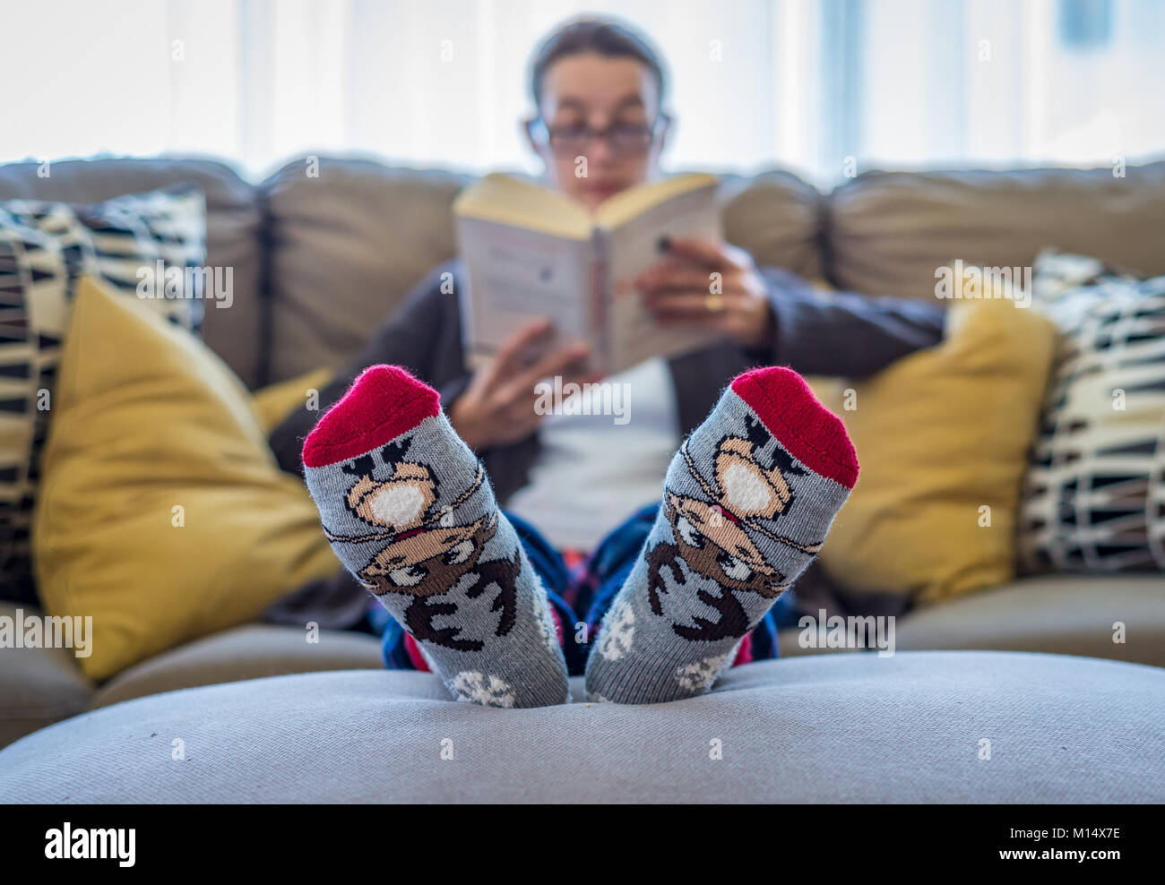 Girl in warm socks reading a book. Selective focus Stock Photo Alamy