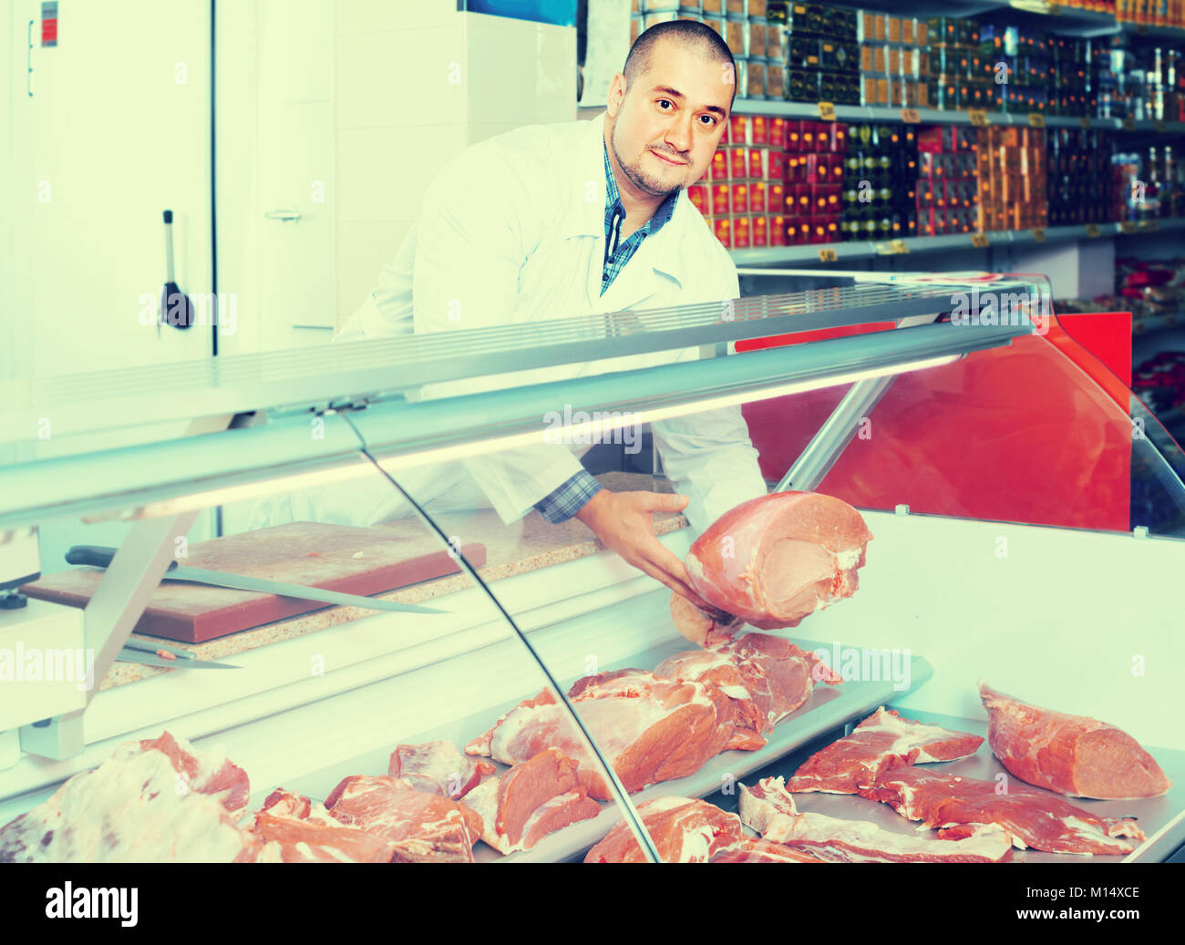 Male shop staff selling halal meat at counter and smiling in supermarket Stock Photo Alamy