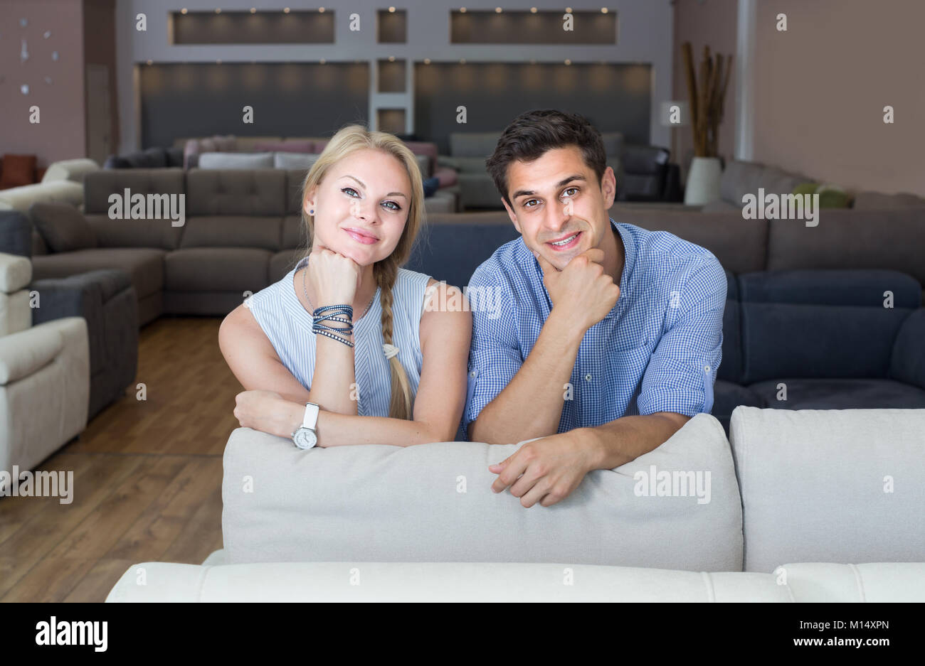 Boyfriend and girlfriend are satisfied by buying new sofa in furniture