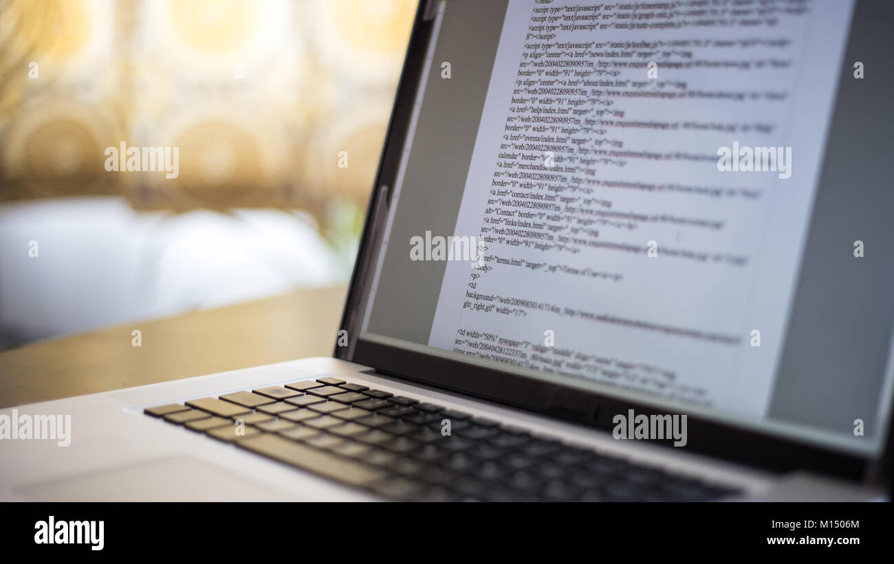 HTML website computer code is displayed on a laptop computer screen ...