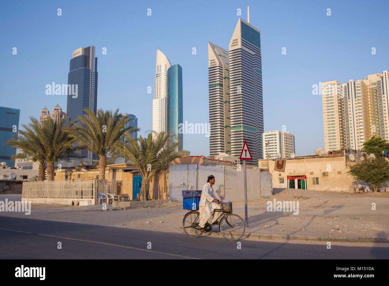 United Arab Emirates, Dubai, Sheikh Zayed skyline with ancient house and workers Stock Photo