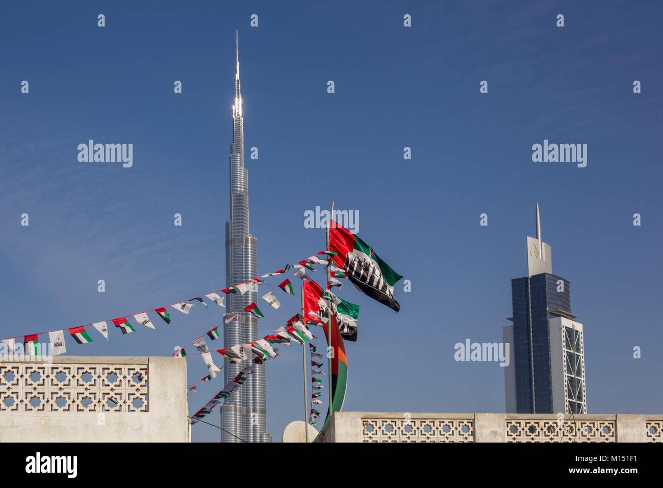 United Arab Emirates, Dubai, Burj Khalifa and other towers at Business bay with emirati flags Stock Photo