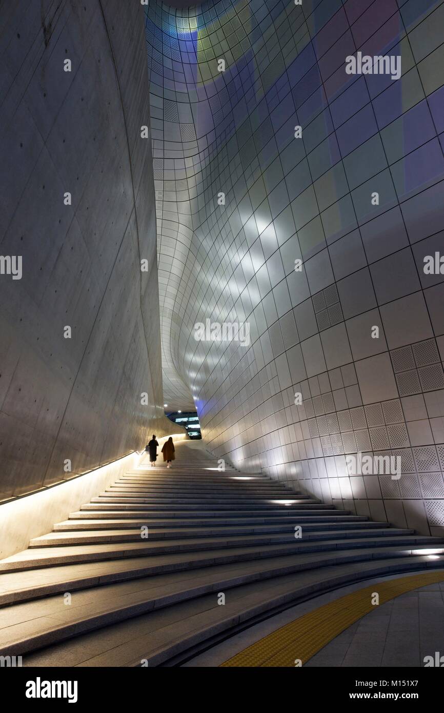 South Korea, Seoul, people climbing a staircase in the middle of the Dongdaemun Design Plaza, futuristic building of the architect Zaha Hadid, lit at night Stock Photo