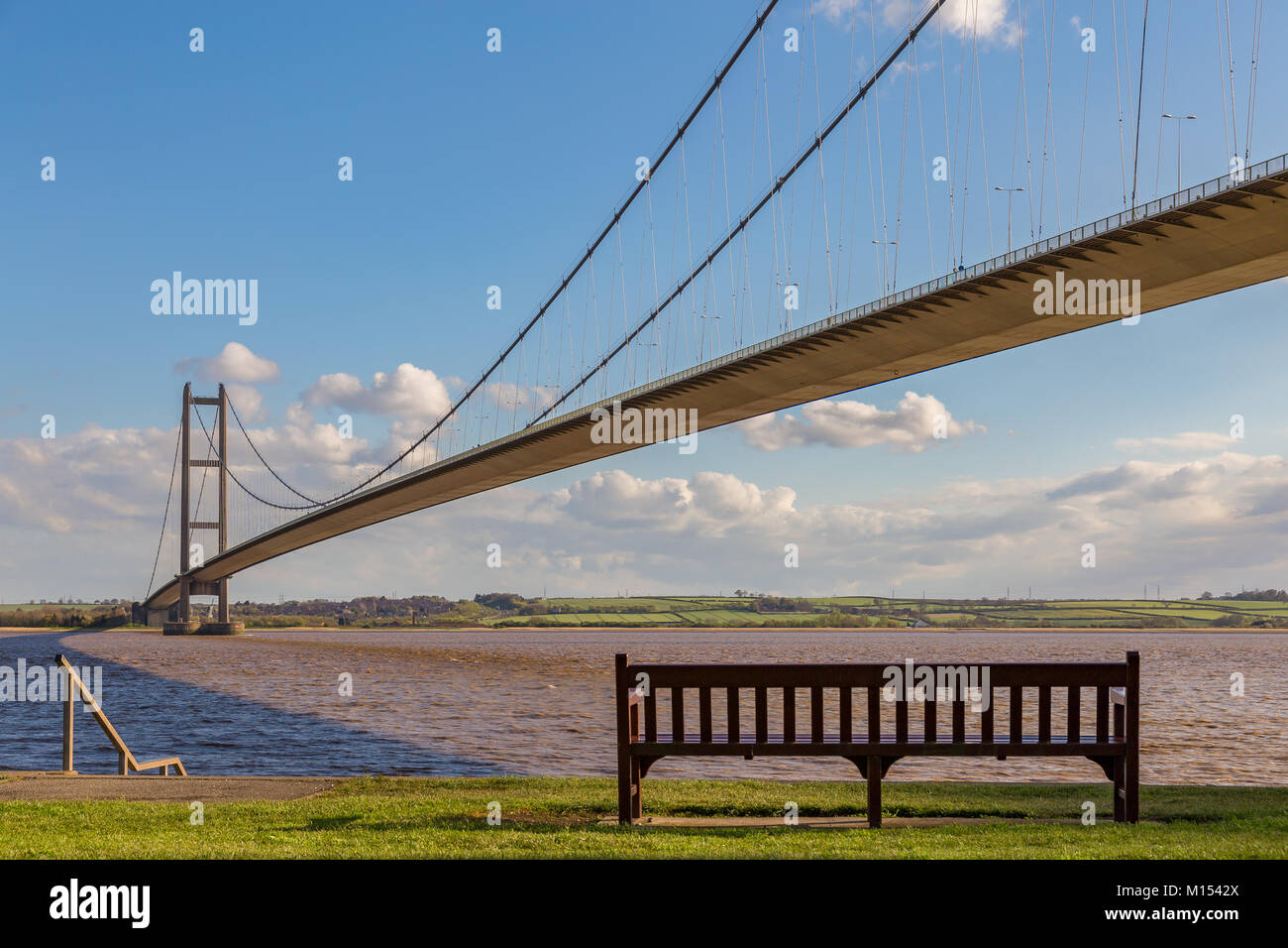 A bench on the shore of the Humber Bridge in Hessle, East Riding of Yorkshire, UK - looking towards Barton-upon-Humber Stock Photo