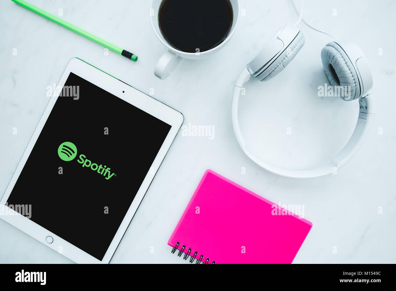 LONDON - JANUARY 25, 2018: Music headphones and Spotify music streaming app with logo on white iPad tablet Stock Photo