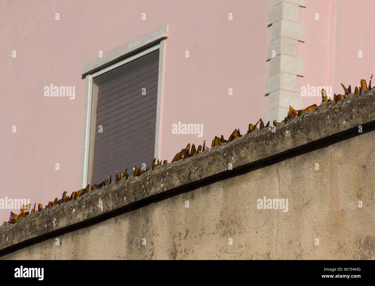 A boundary wall with broken glass as a deterrent against burglars or