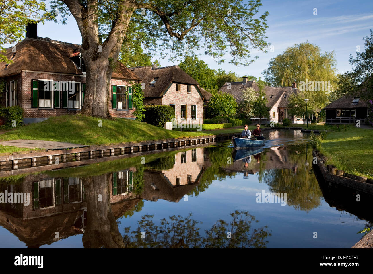 The Netherlands, Dwarsgracht, near Giethoorn, Village with almost only waterways. Tourist couple enjoying boat ride. Stock Photo