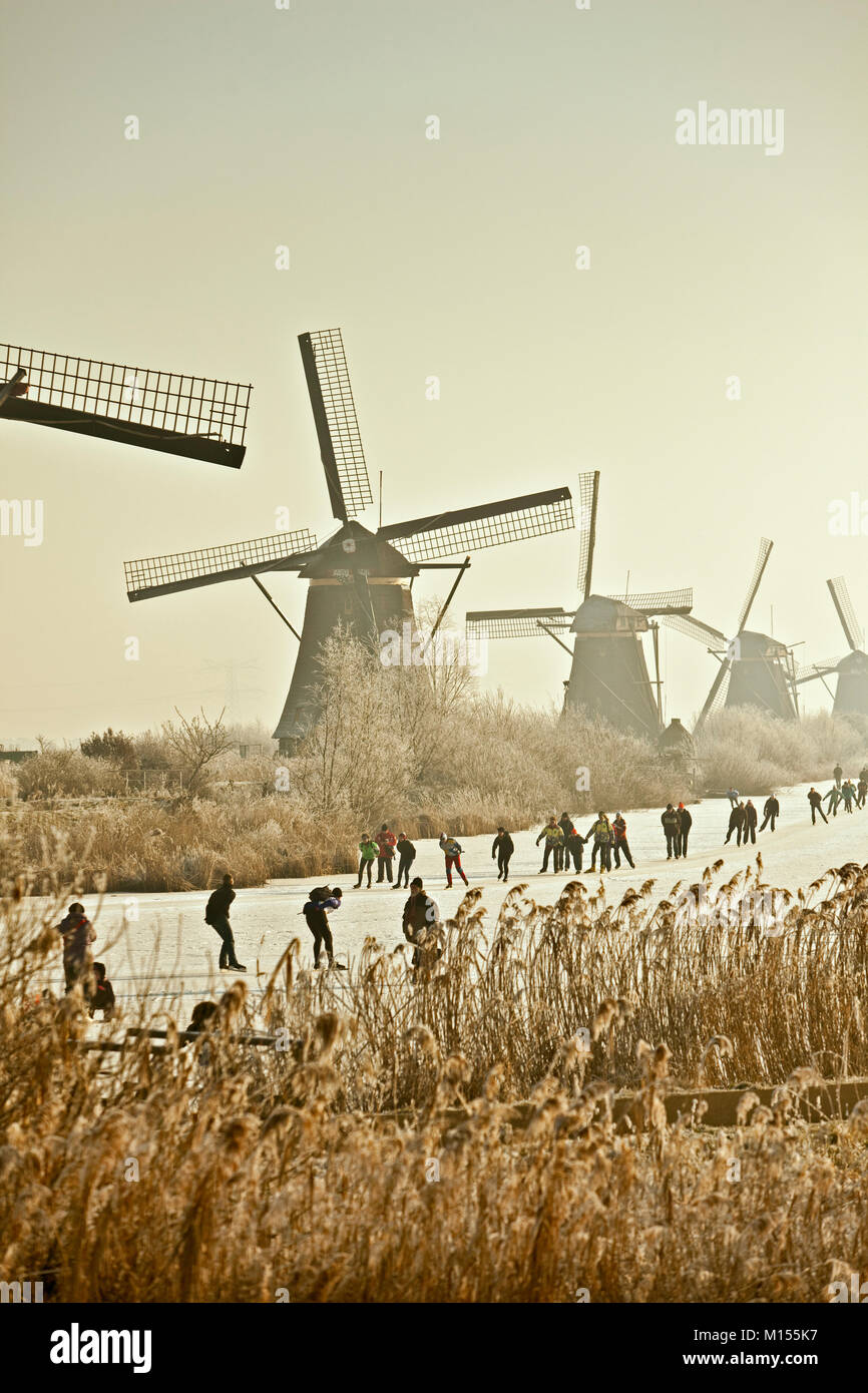 The Netherlands, Kinderdijk, Windmills, Unesco World Heritage Site. People ice skating. Winter. Stock Photo