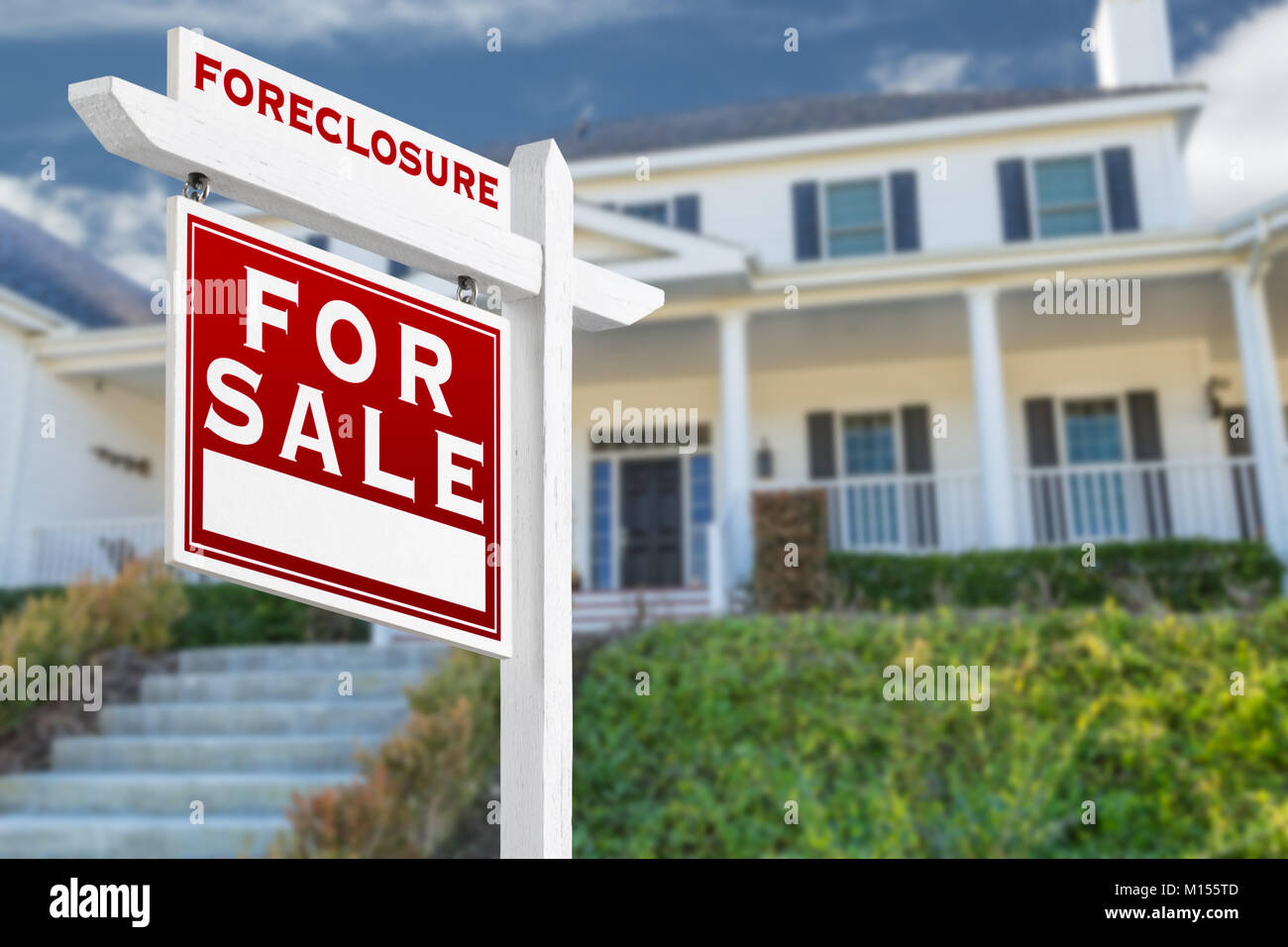 Left Facing Foreclosure For Sale Real Estate Sign in Front of House. Stock Photo