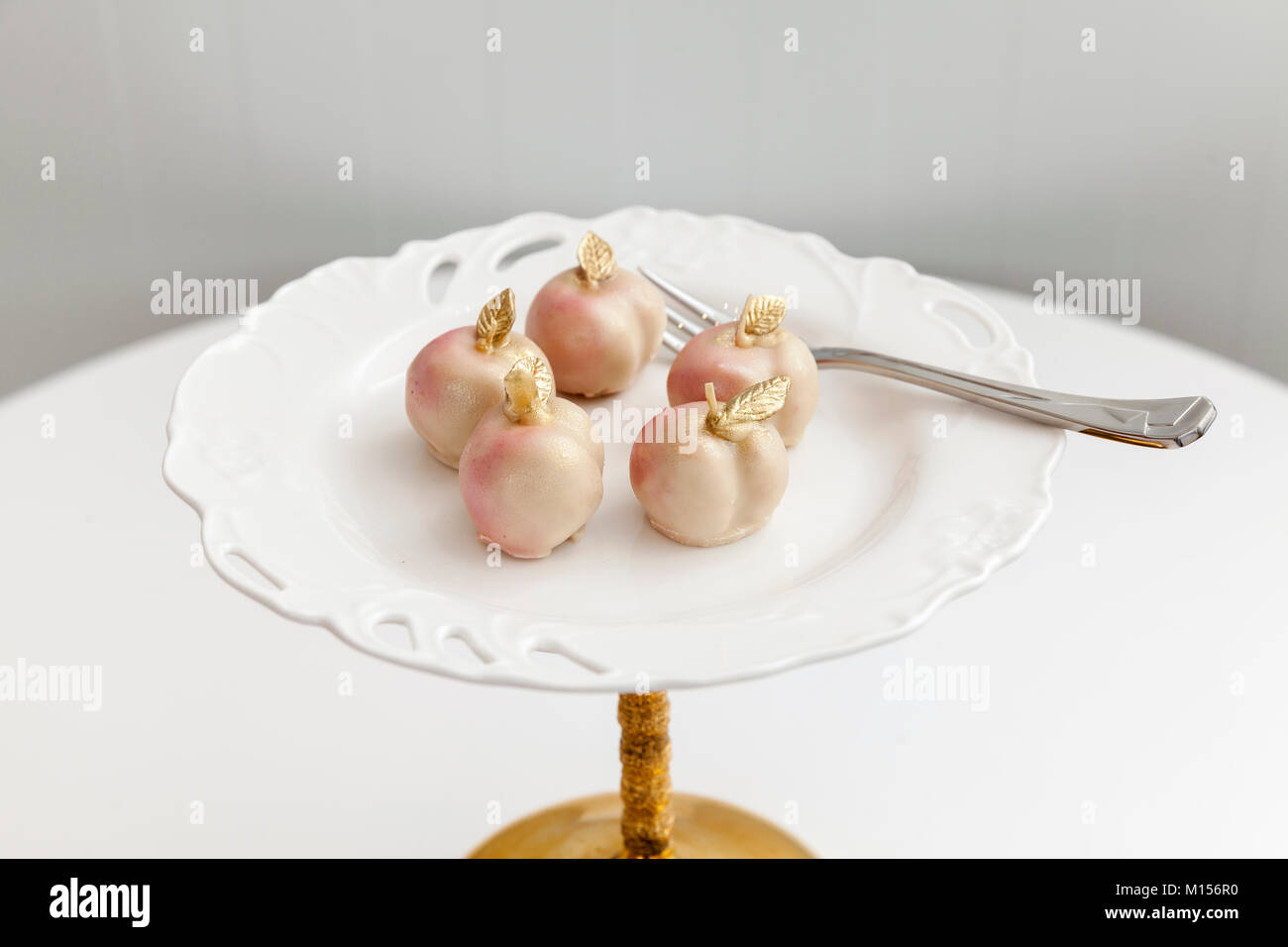 little cakes in the shape of a peach on a white plate Stock Photo