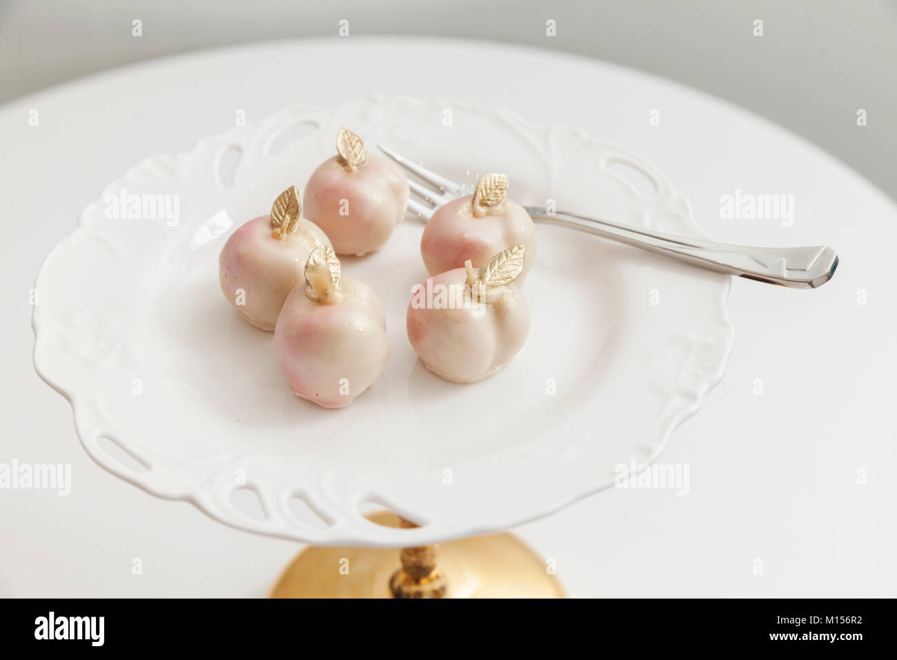 little cakes in the shape of a peach on a white plate Stock Photo
