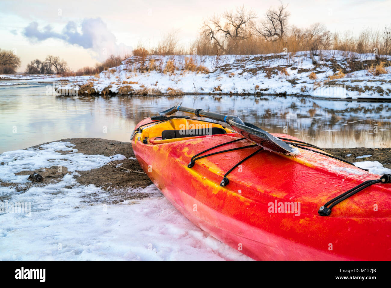 winter kayaking in Colorado red whitewater kayak with a paddle on