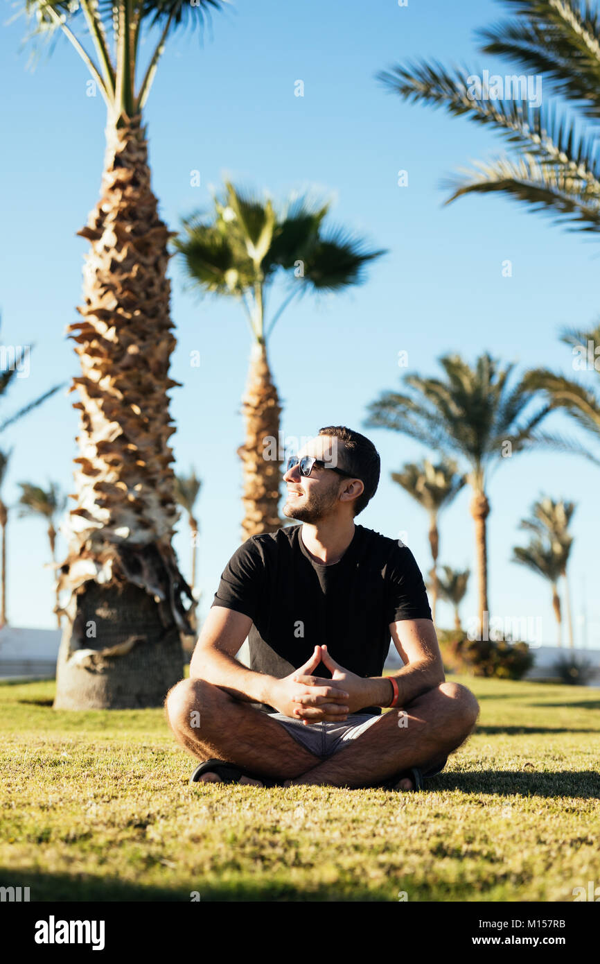 On person sitting under palm tree hi-res stock photography and images ...