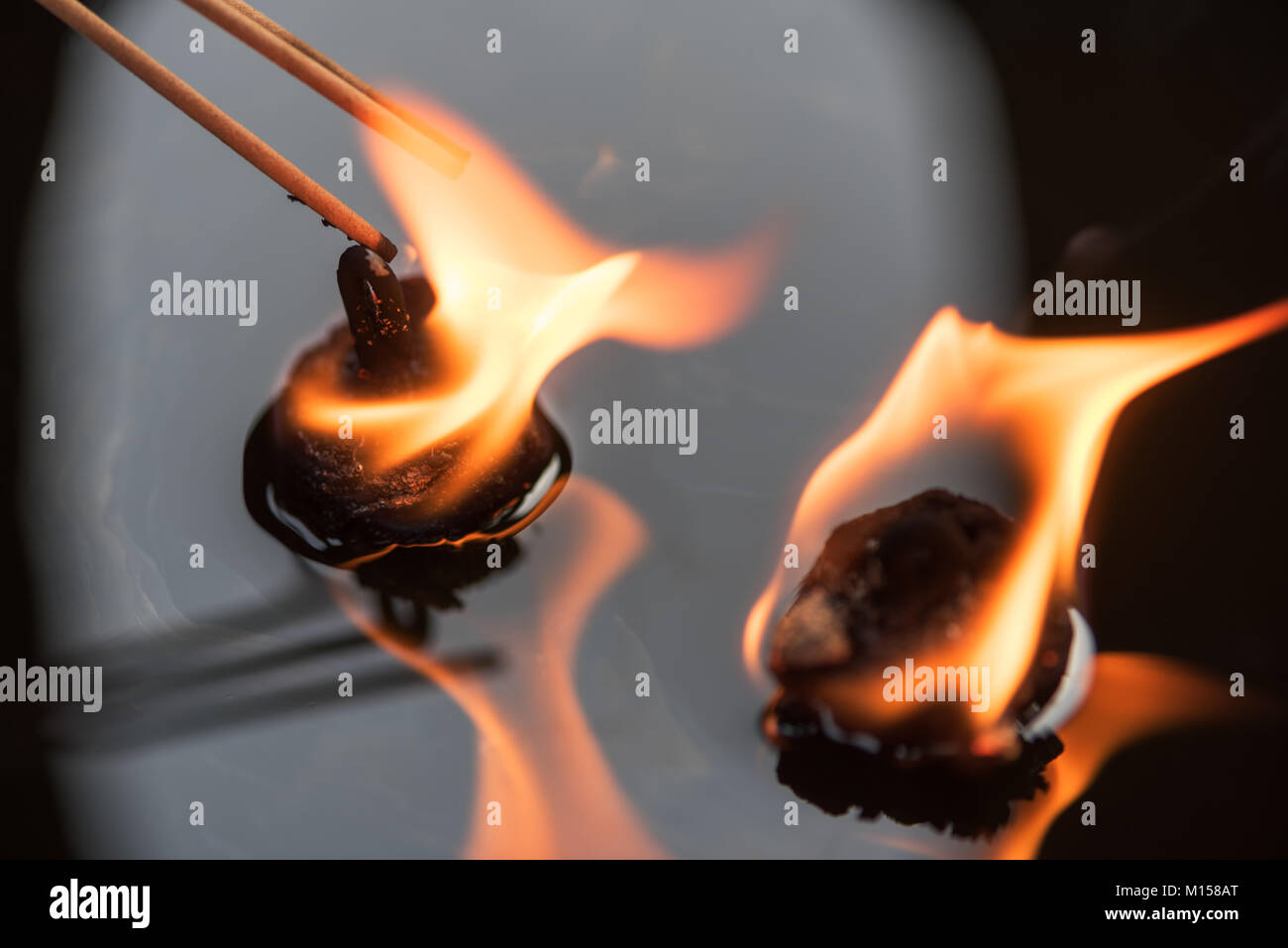 Incense sticks lightened with oil candles, Chengdu, China Stock Photo