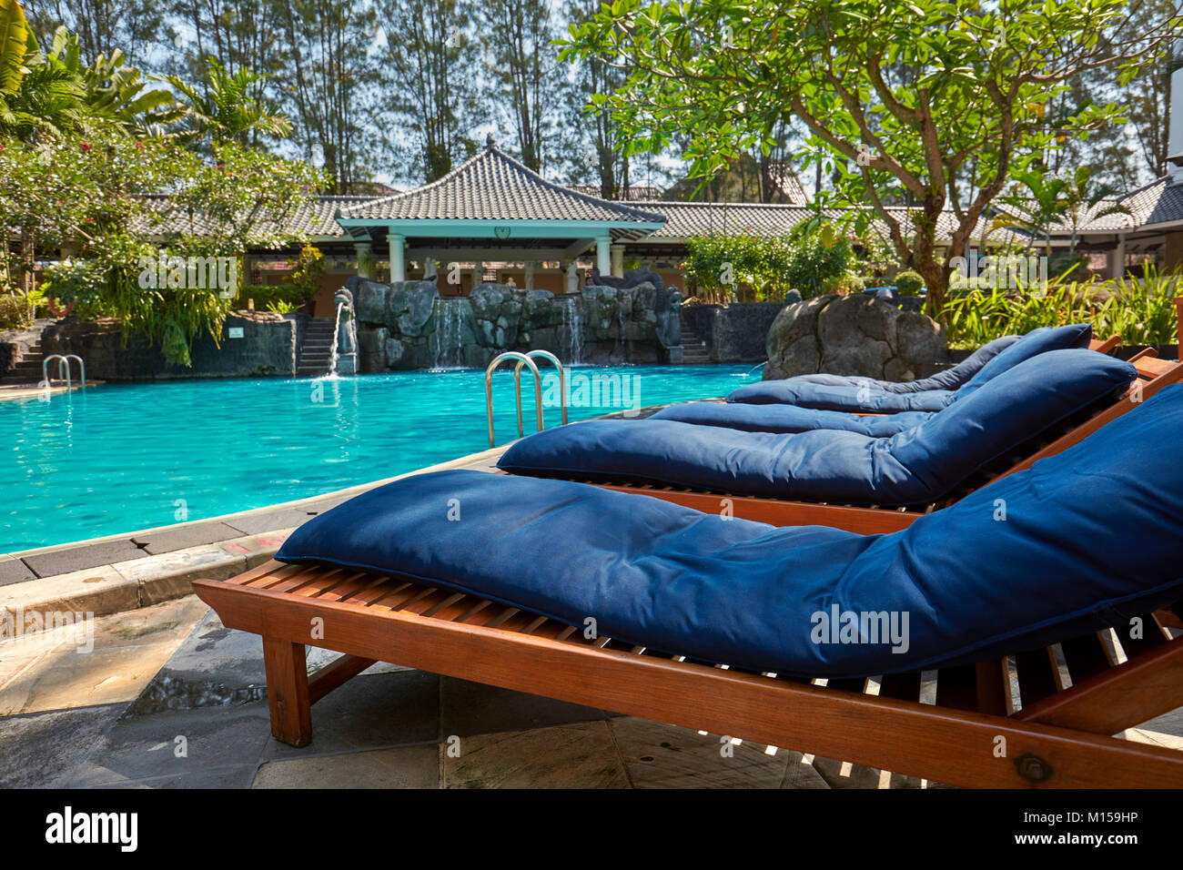 Loungers at the swimming pool. Melia Purosani Hotel, Yogyakarta, Java, Indonesia. Stock Photo