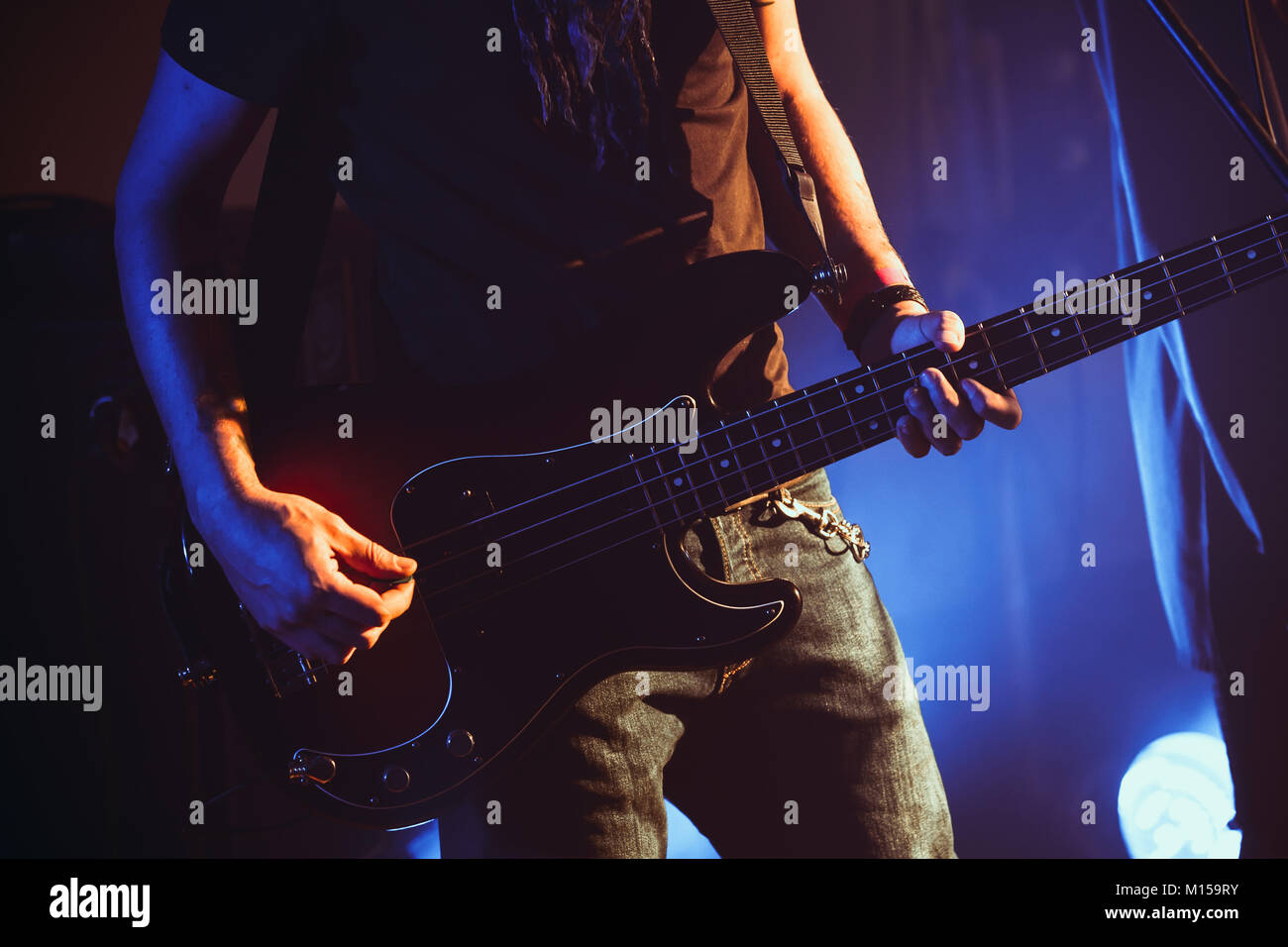 Rock music theme, electric bass guitar player, closeup photo with soft selective focus Stock Photo