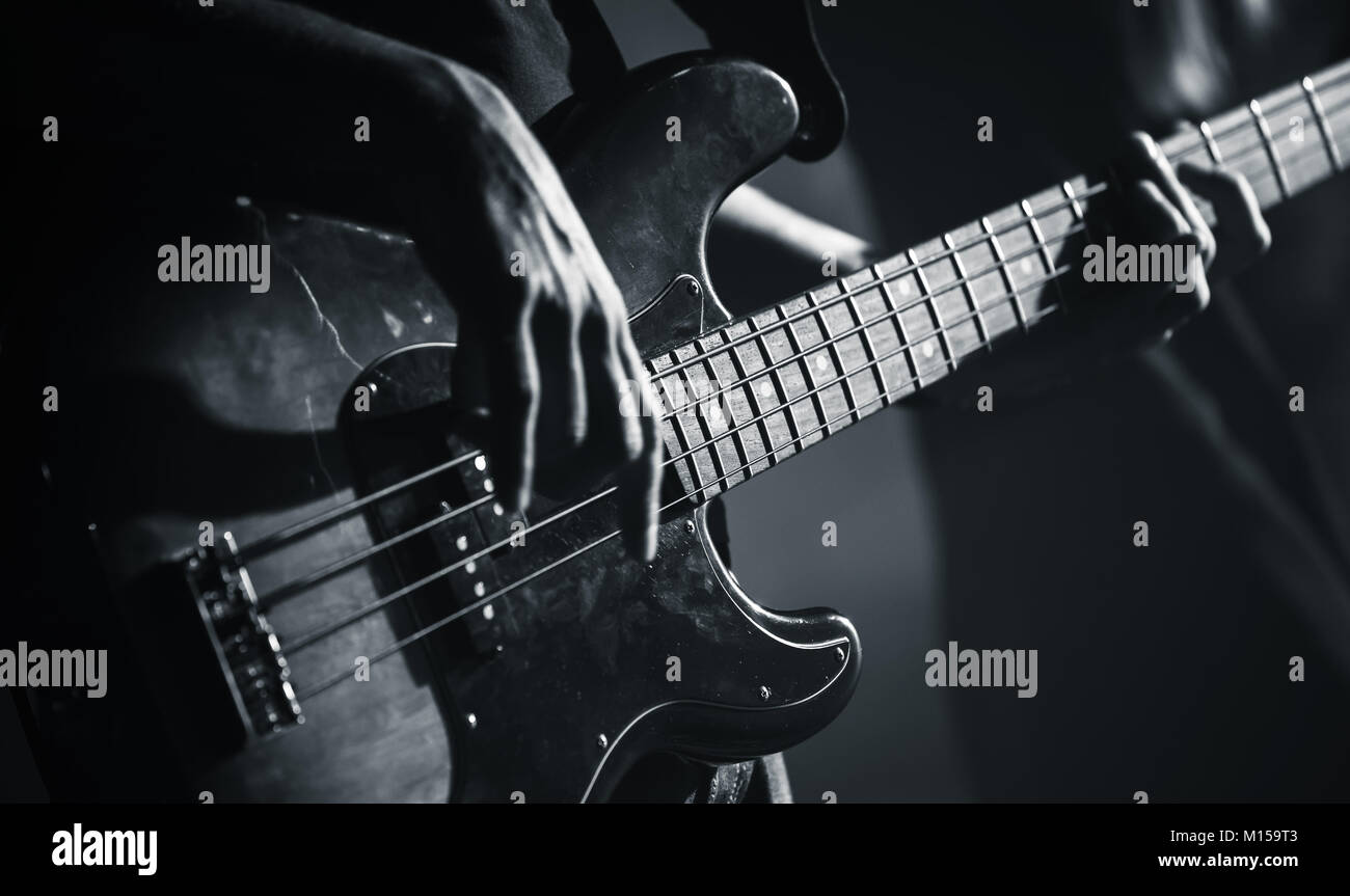 Electric bass guitar player hands, live music theme, black and white photo Stock Photo