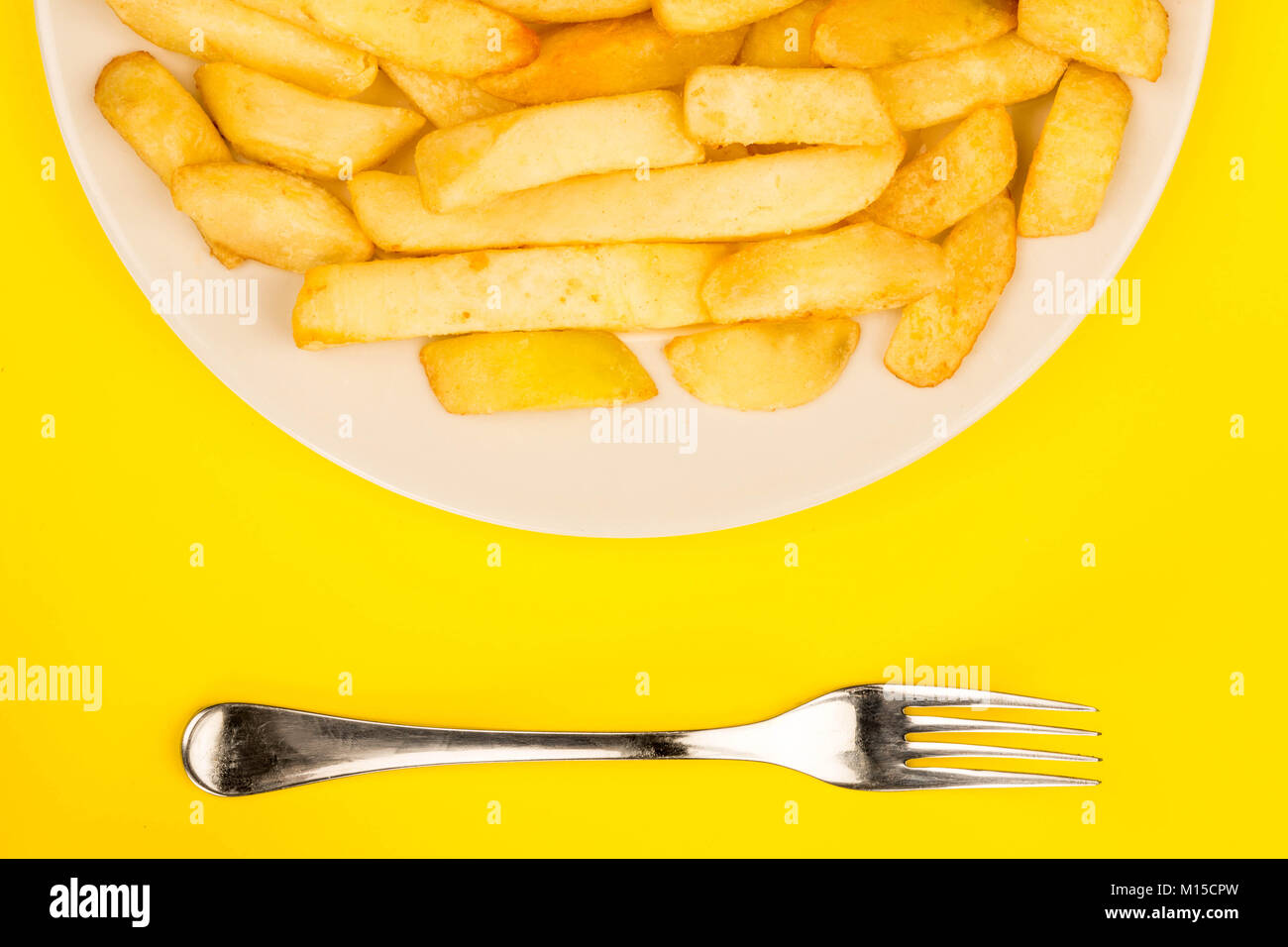 Plate of Chips Against A Yellow Background Stock Photo