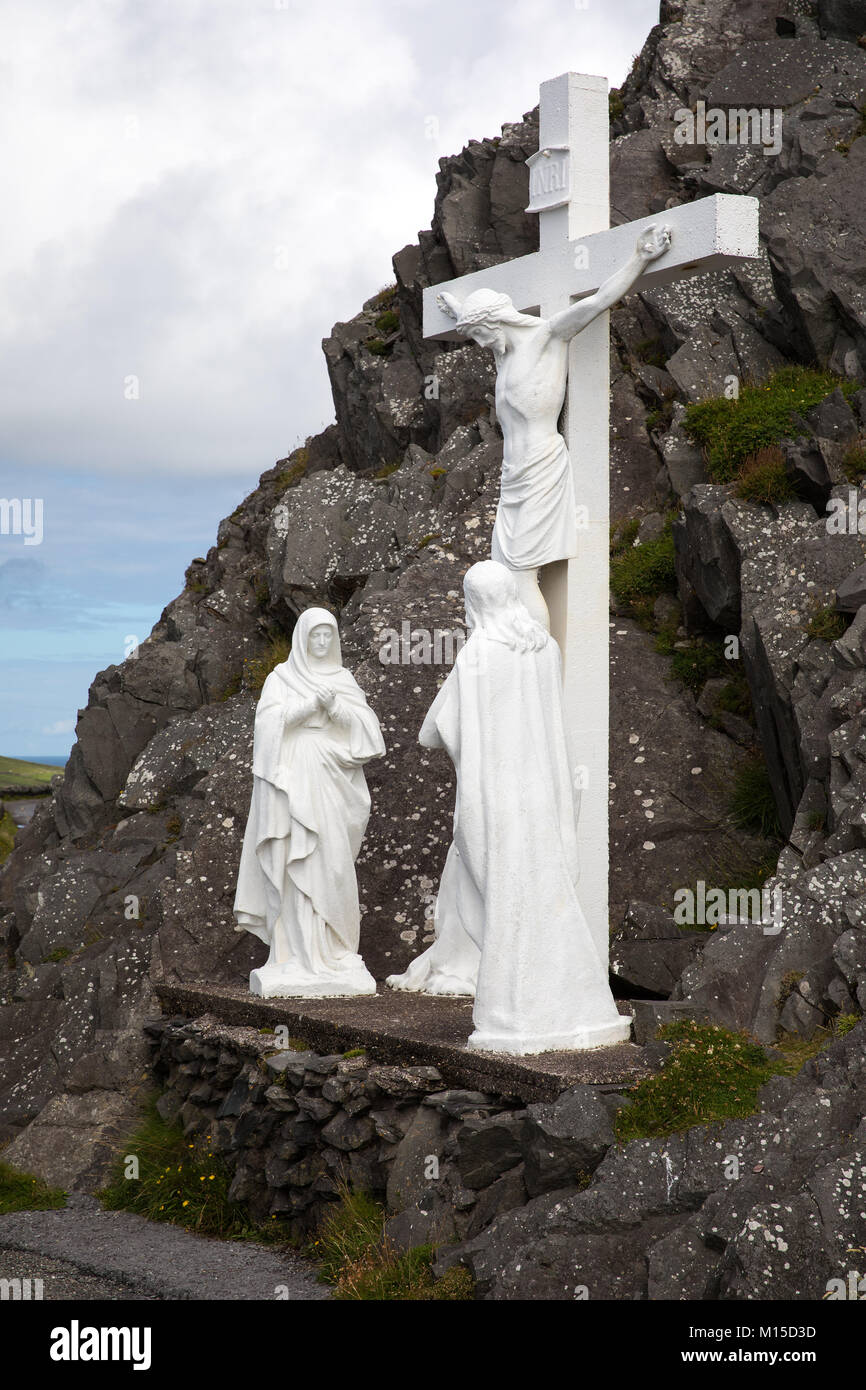 A white crucifix stands at the dark cliffs of the Slea Head Drive on the Dingle Peninsula, Ireland. Stock Photo