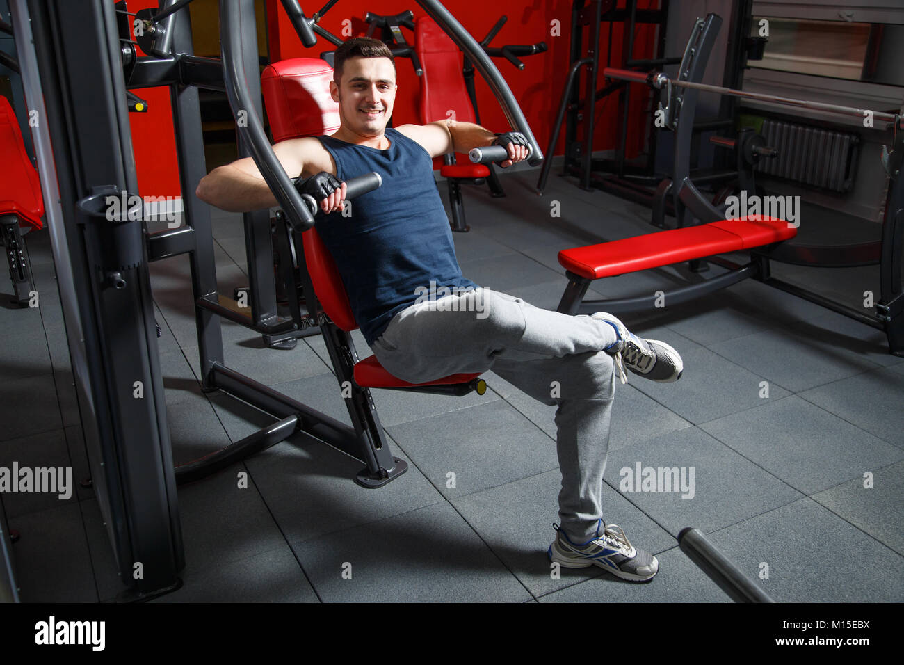 Portrait of a smiling muscular man showing thumbs up at gym Stock Photo