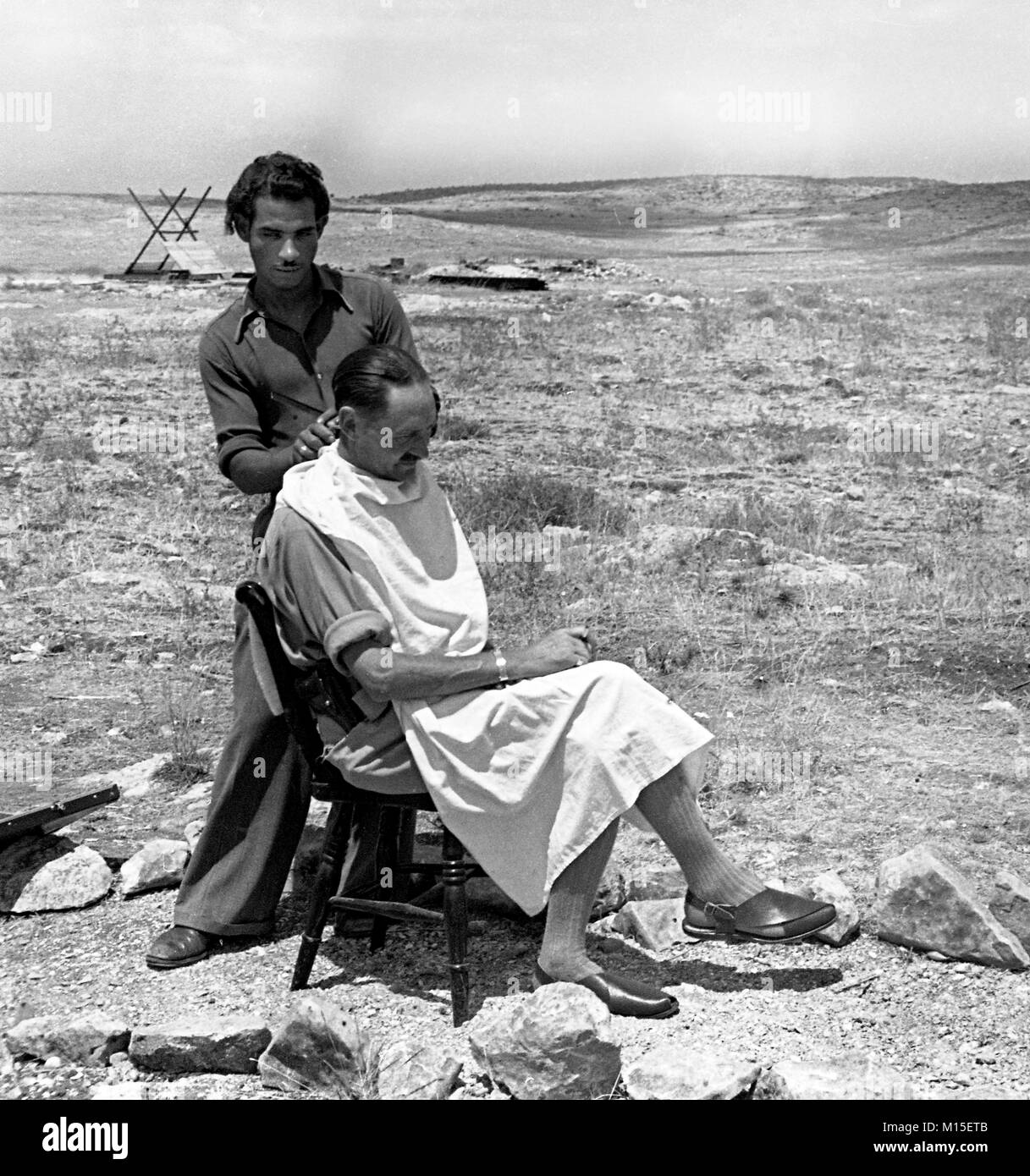 British army soldier getting a haircut from a Palestinian barber in Palestine 1940 Stock Photo