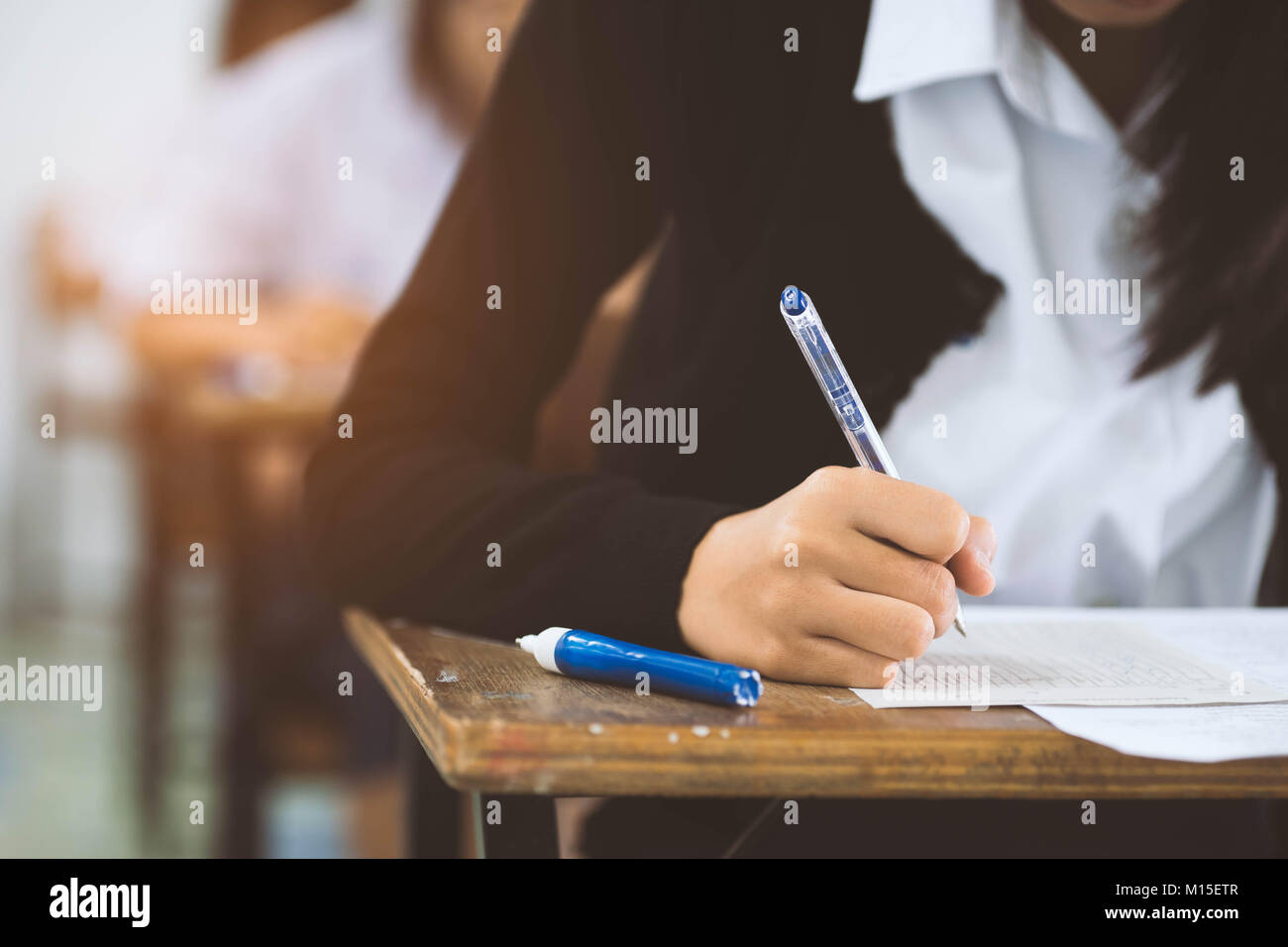 Close up hand of student reading and writing exam with stress in