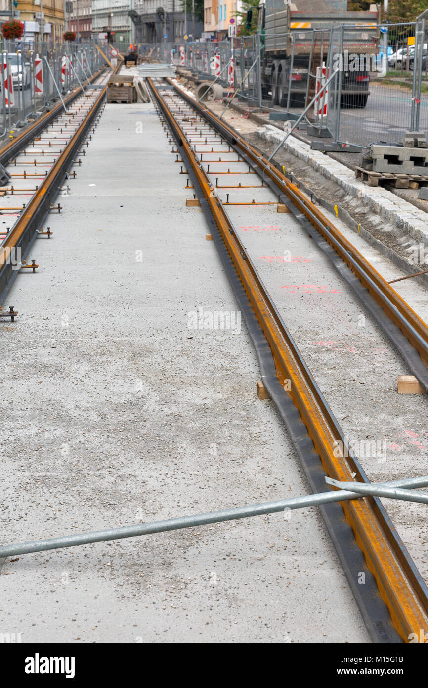 Repair works on the street. Laying of new tram rails on a city street. Installation of new modern silent railway rails for trams. Stock Photo