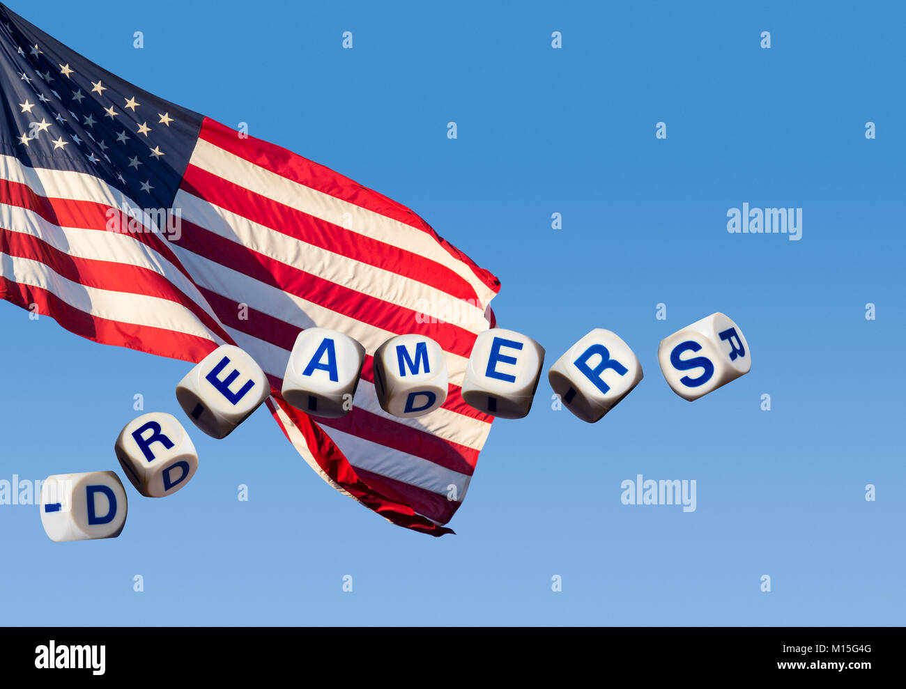 Dreamers concept using spelling letters against blue sky and flag Stock Photo