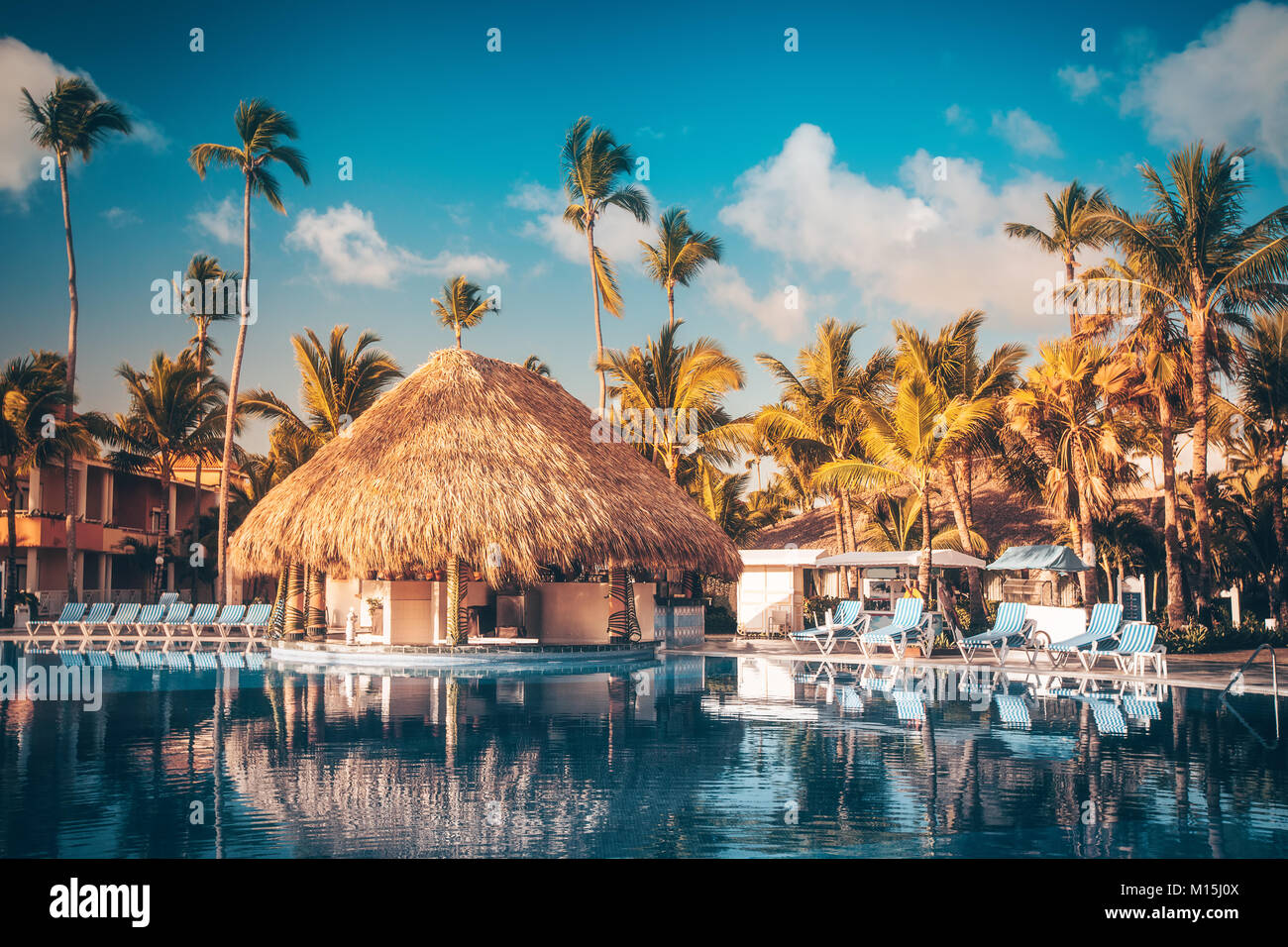 Tropical swimming pool and palm trees in luxury resort Stock Photo - Alamy