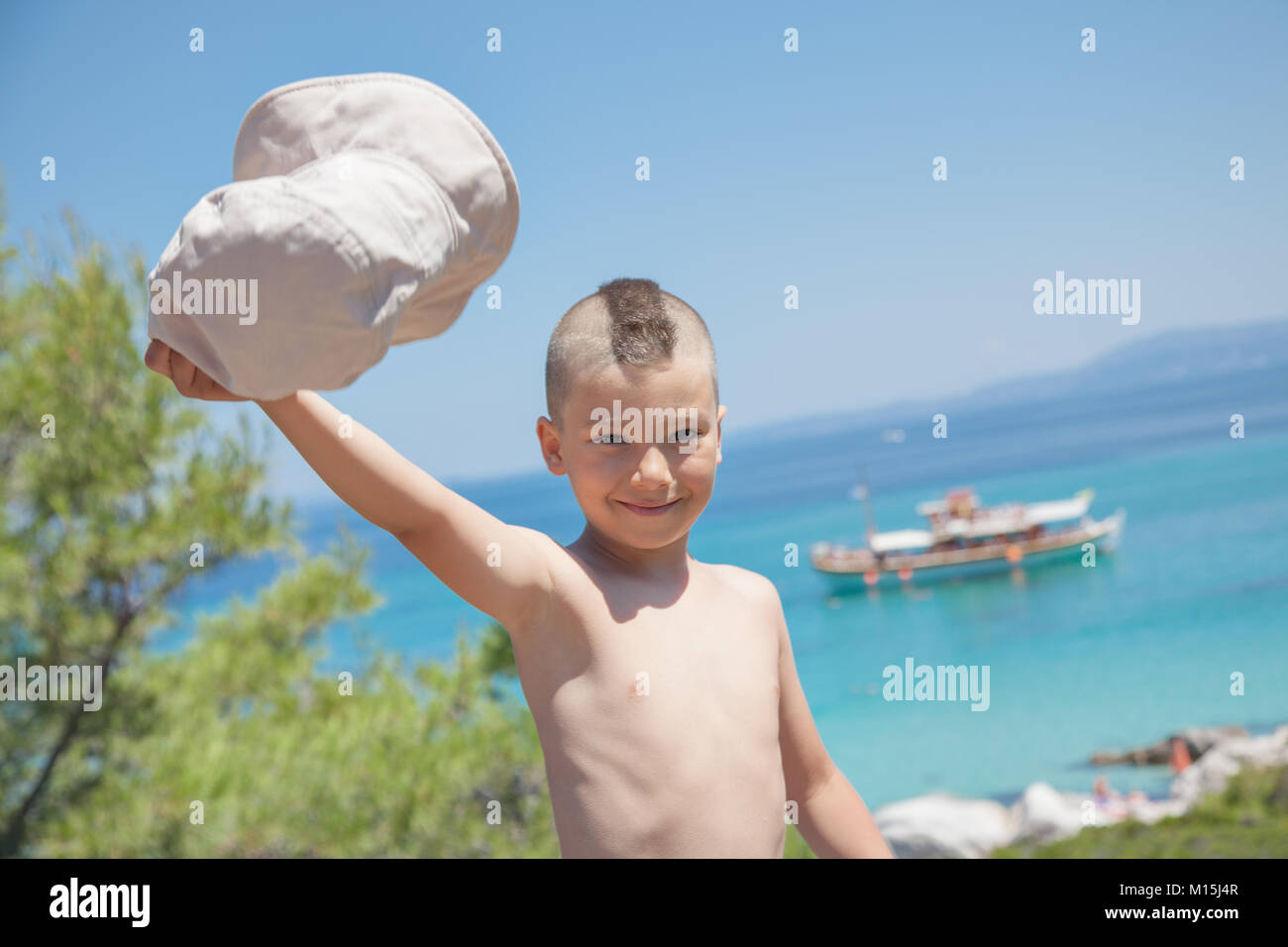 Boy Waving Hat Sea Shore Stock Photo