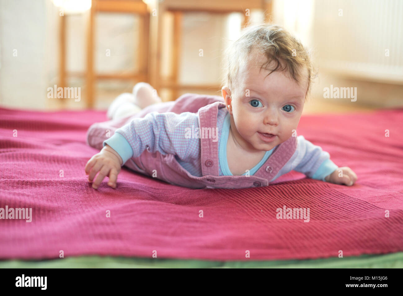 Baby girl lies on her stomach Stock Photo