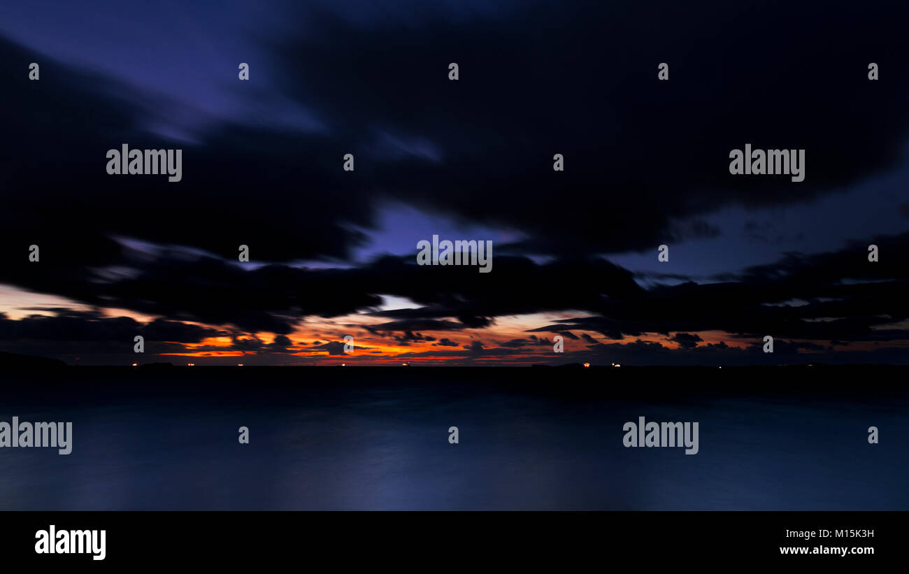 Ships' lights on the horizon at dusk at Broad Haven on the welsh coast Stock Photo