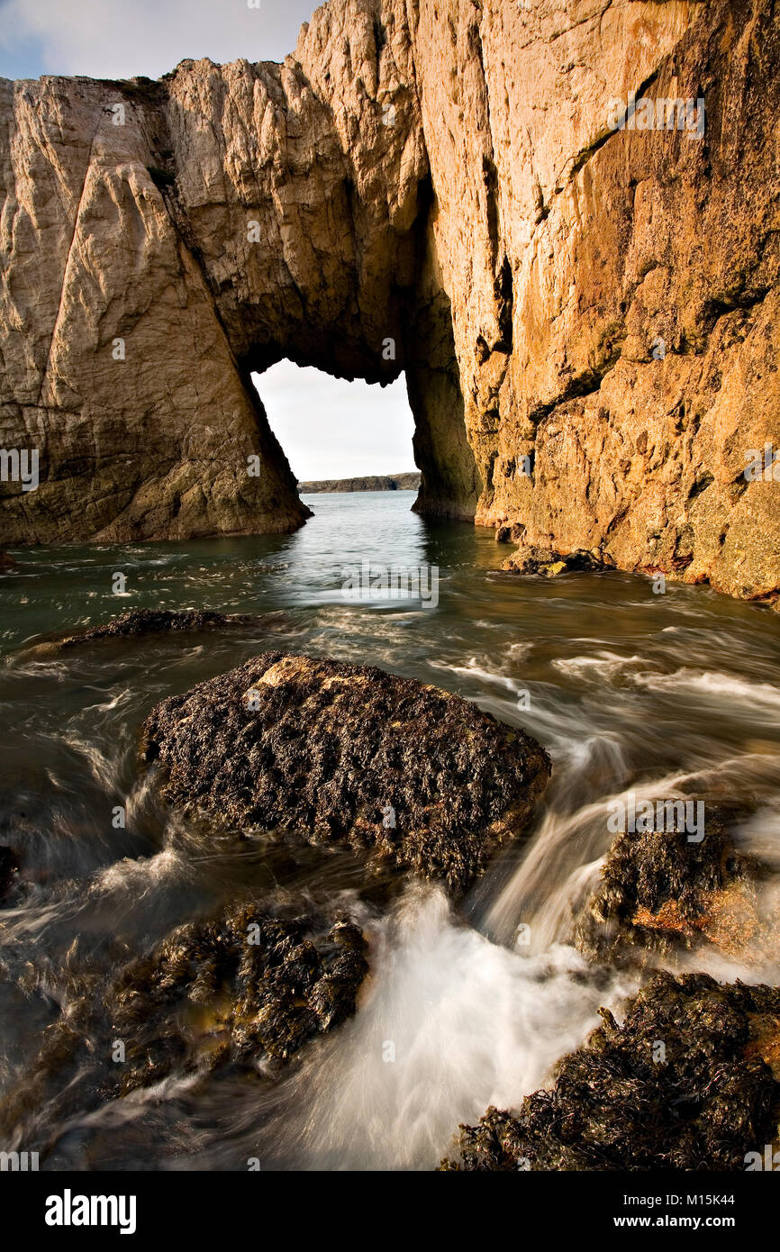 Bwa Gwyn sea arch and cliffs near Rhoscolyn on Anglesey at high tide Stock Photo